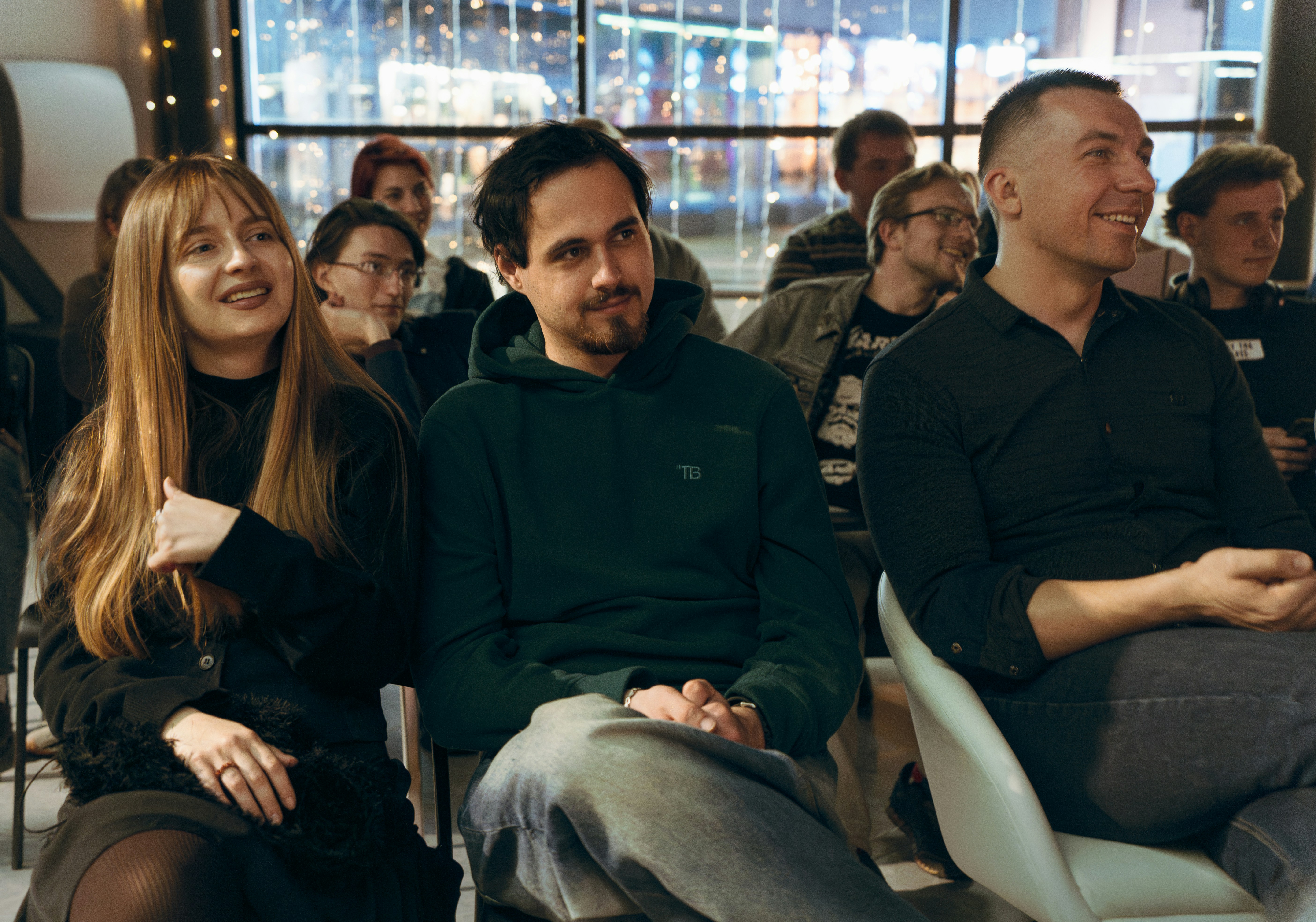 Des gens assis à écouter dans une pièce