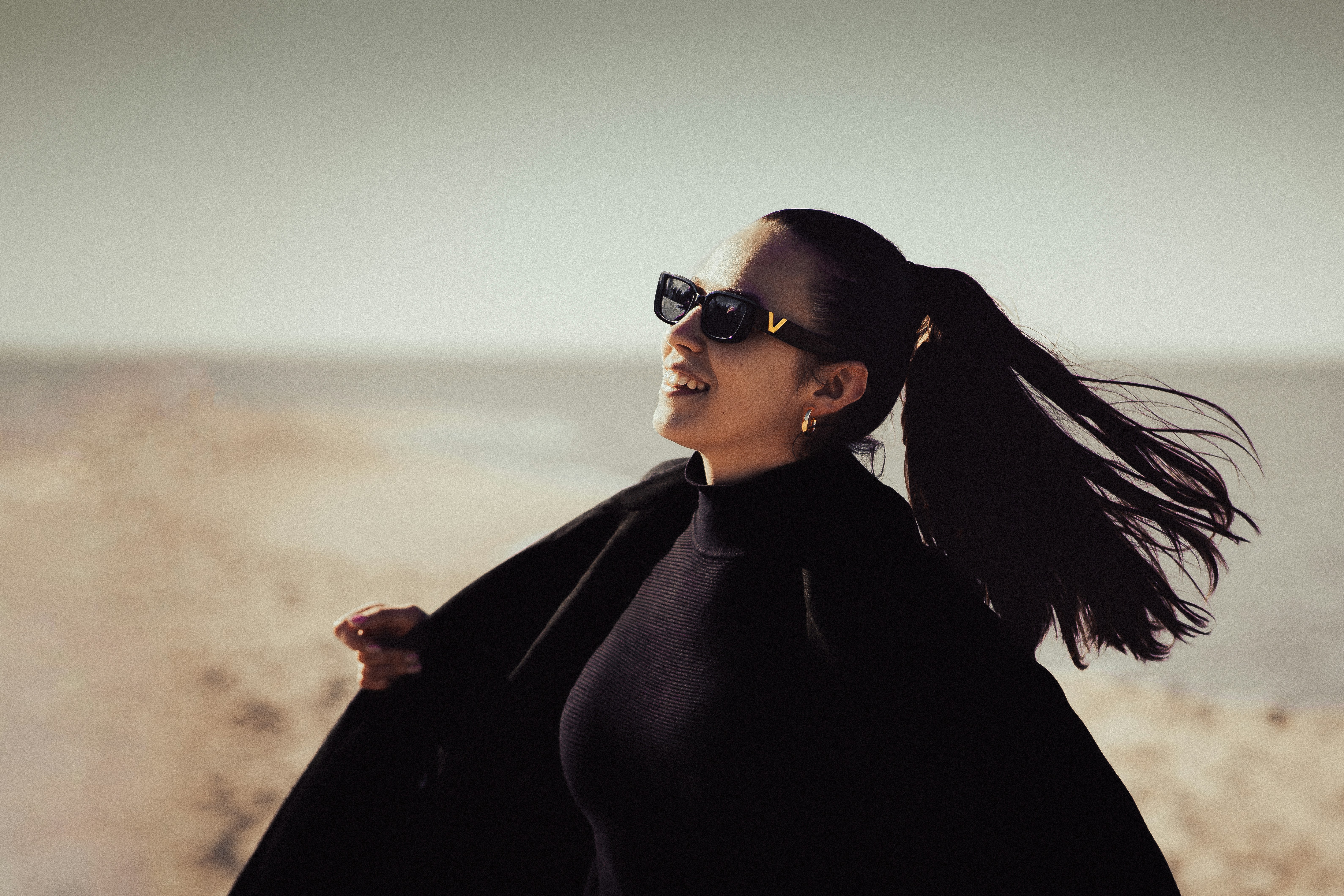 Wanita dengan kacamata hitam dan kuncir kuda di luar ruangan