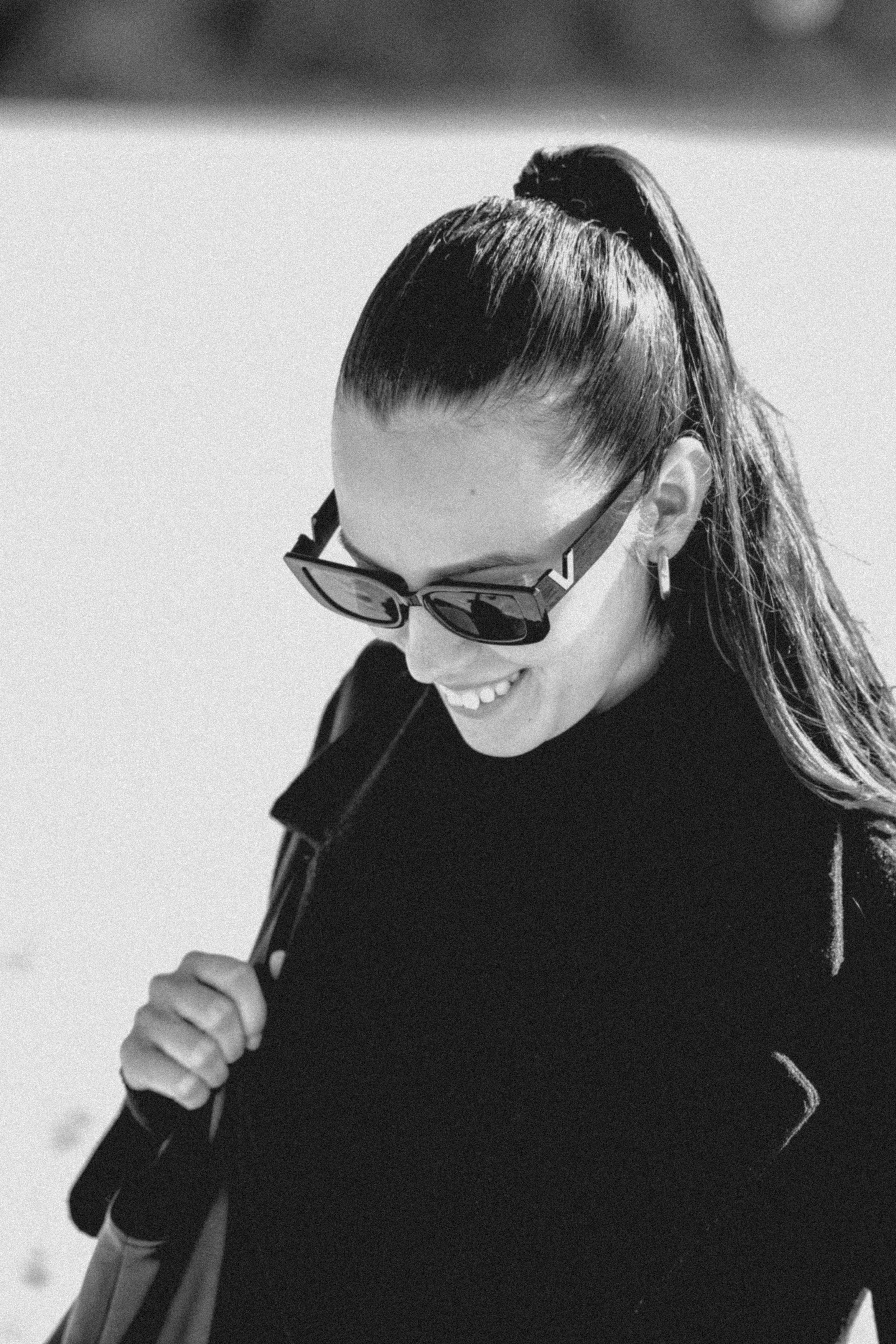 Seorang wanita mengenakan kacamata hitam dan turtleneck hitam