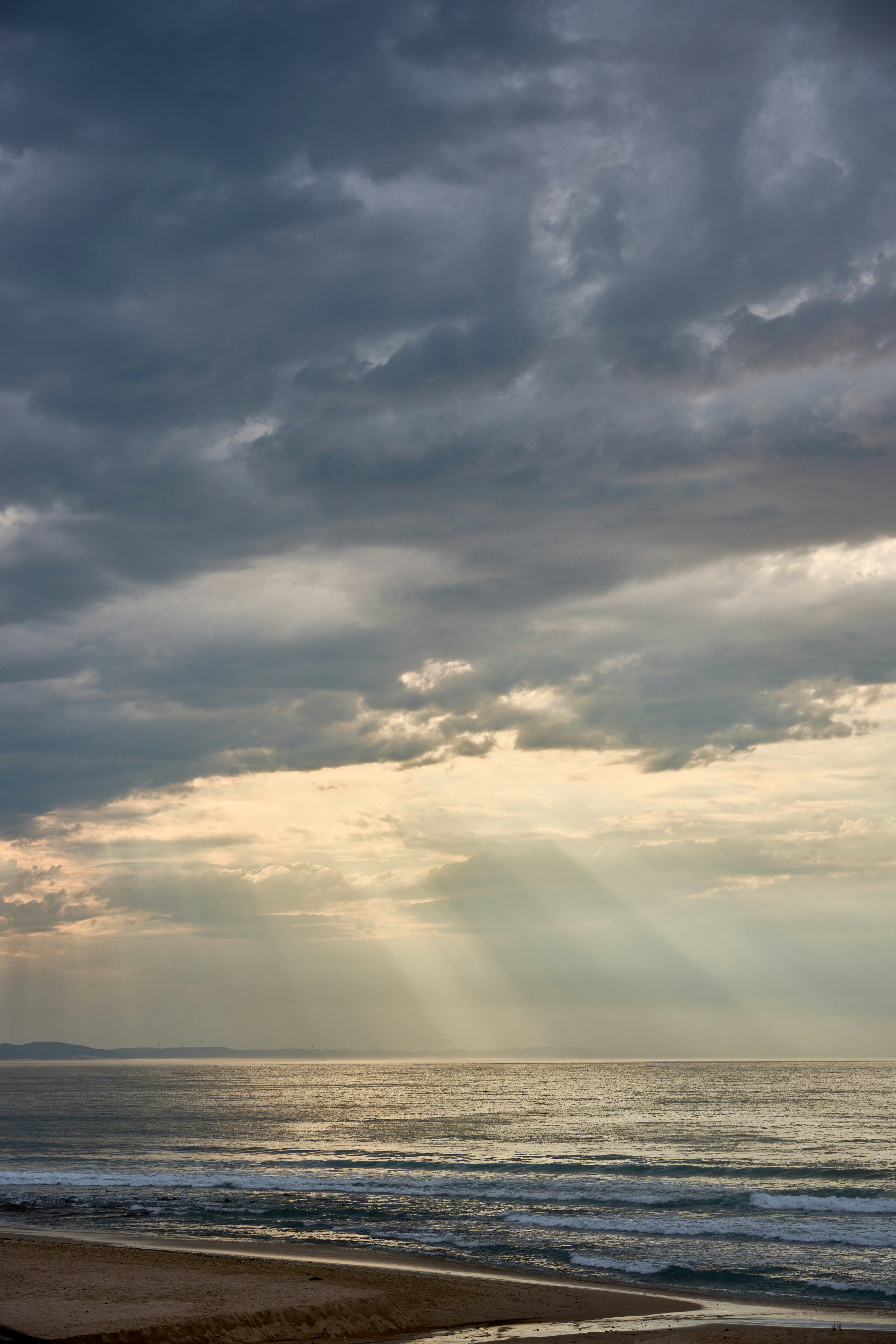 바다 위 극적인 구름을 뚫고 들어오는 햇살