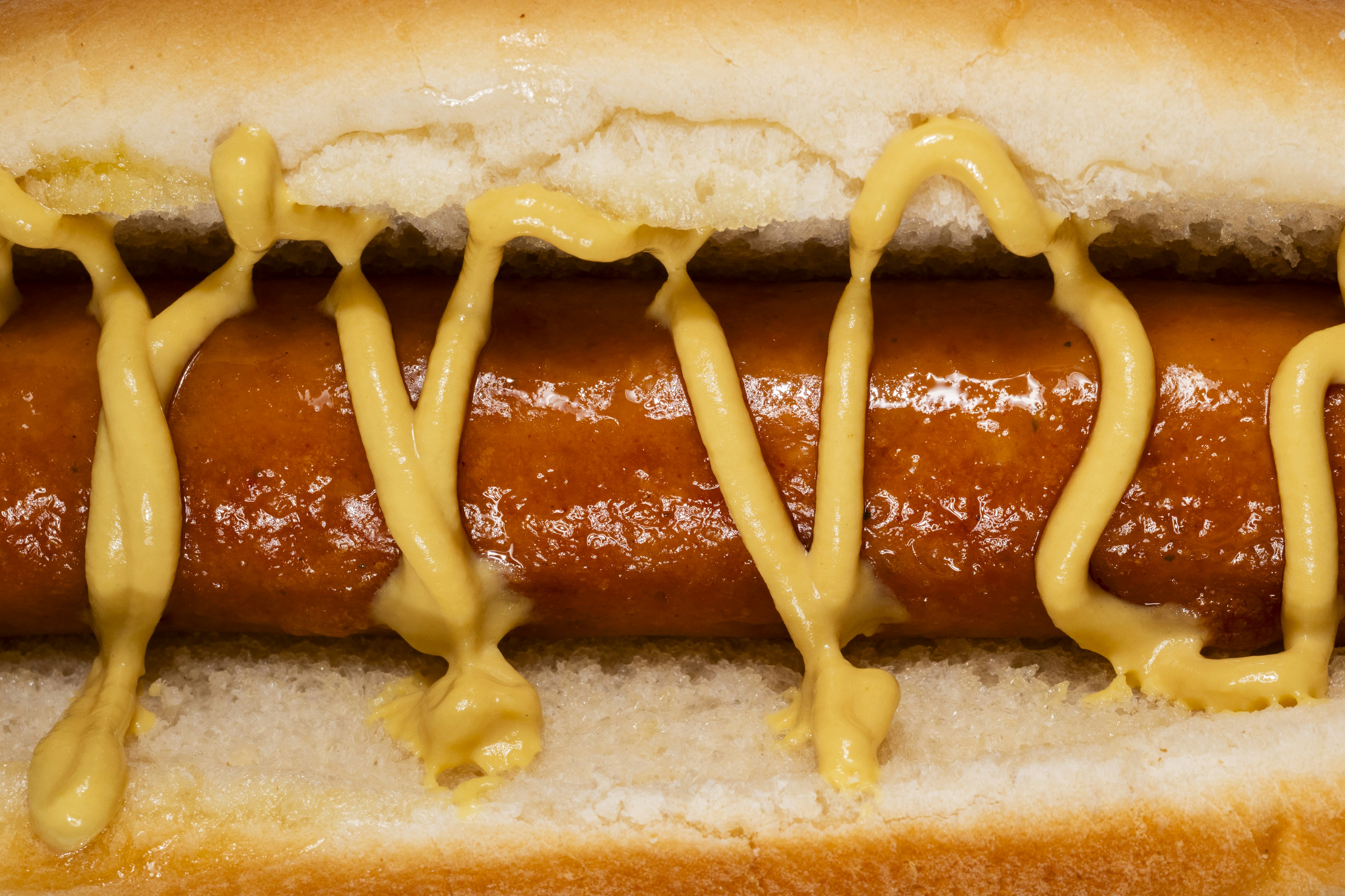 Hot dog with mustard in a bun (Photo by engin akyurt on Unsplash)
