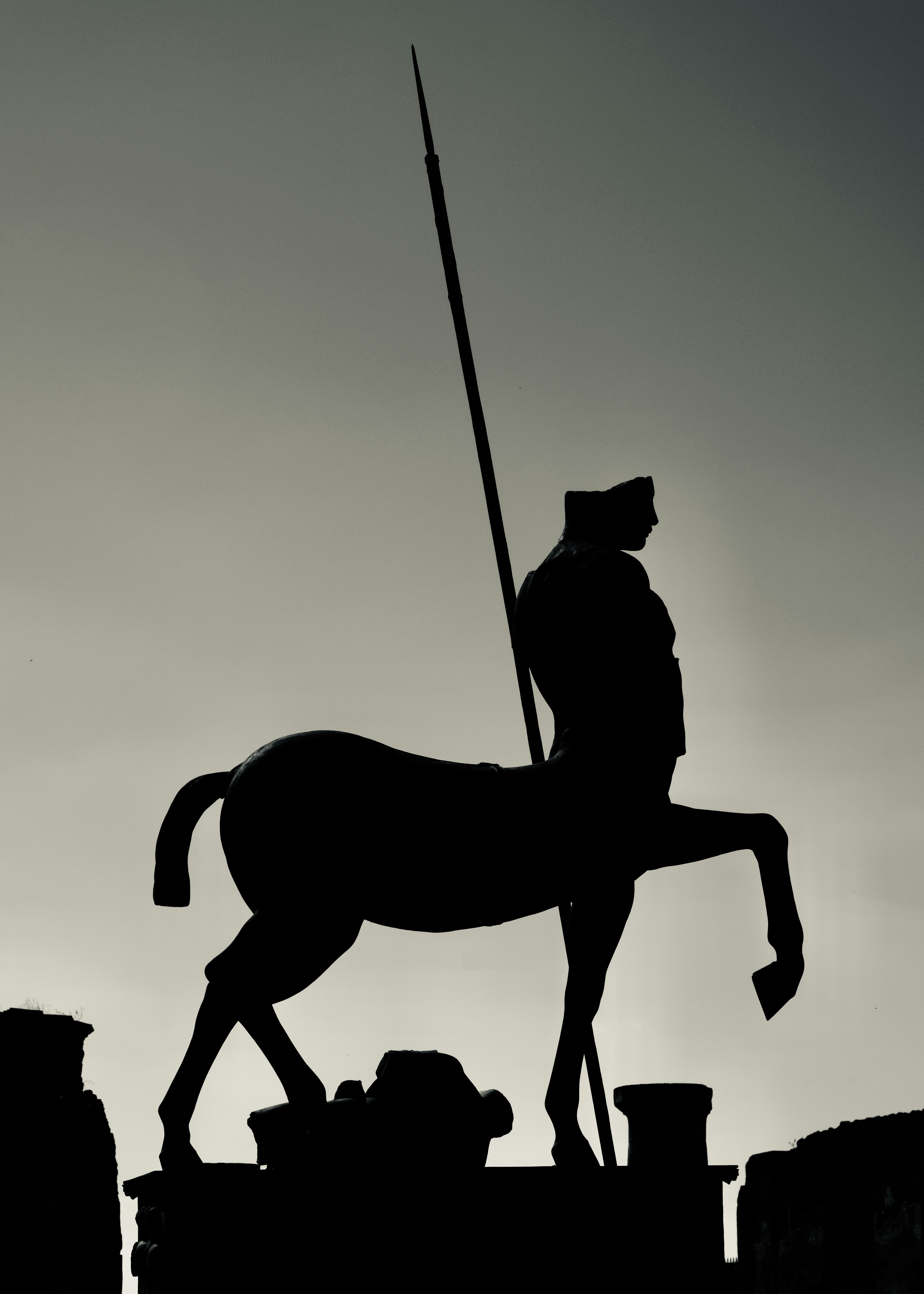 Silhouette of a centaur statue holding a spear.