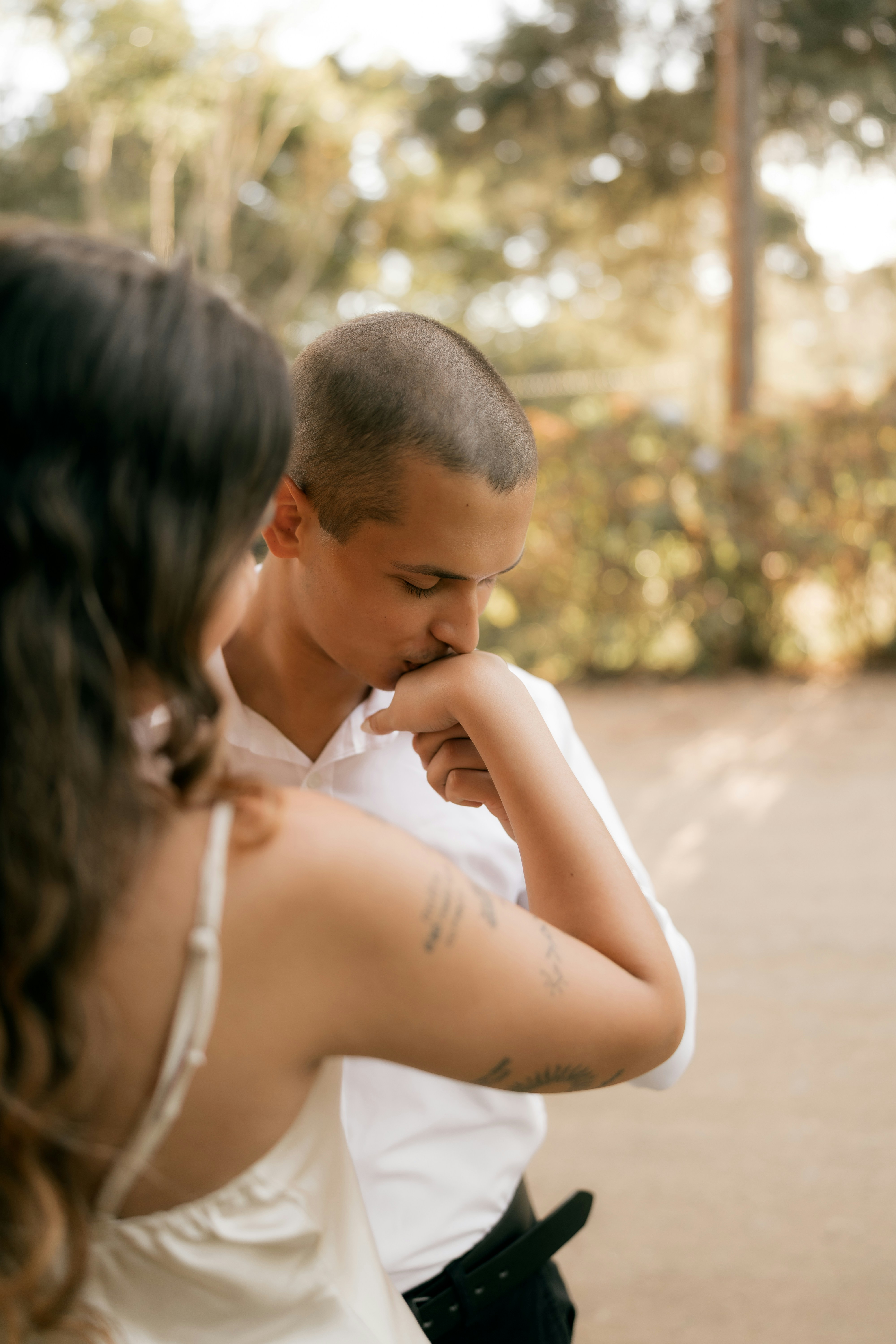 Un uomo bacia la mano di una donna in un gesto romantico.