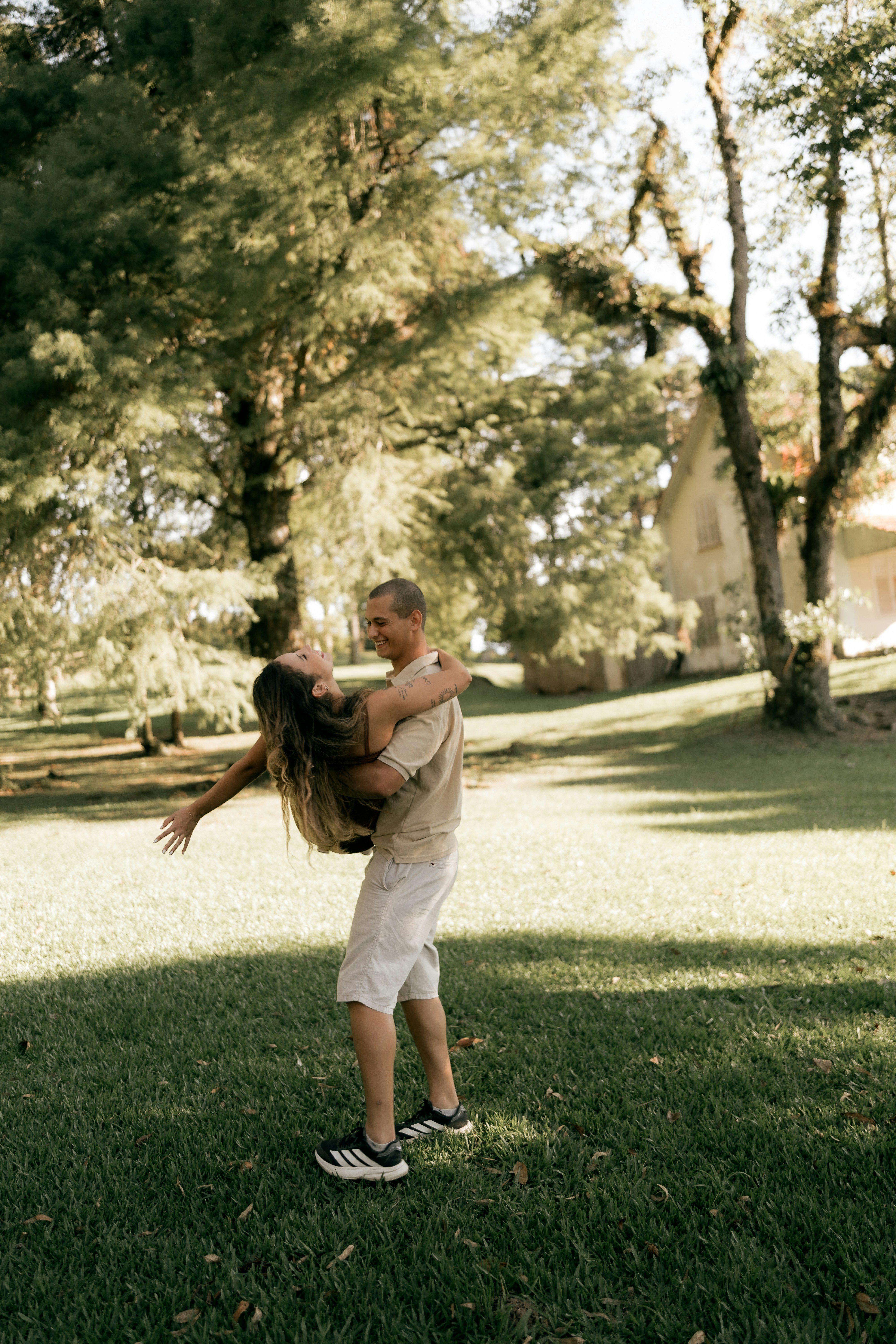 Couple dancing in a sunny park with trees