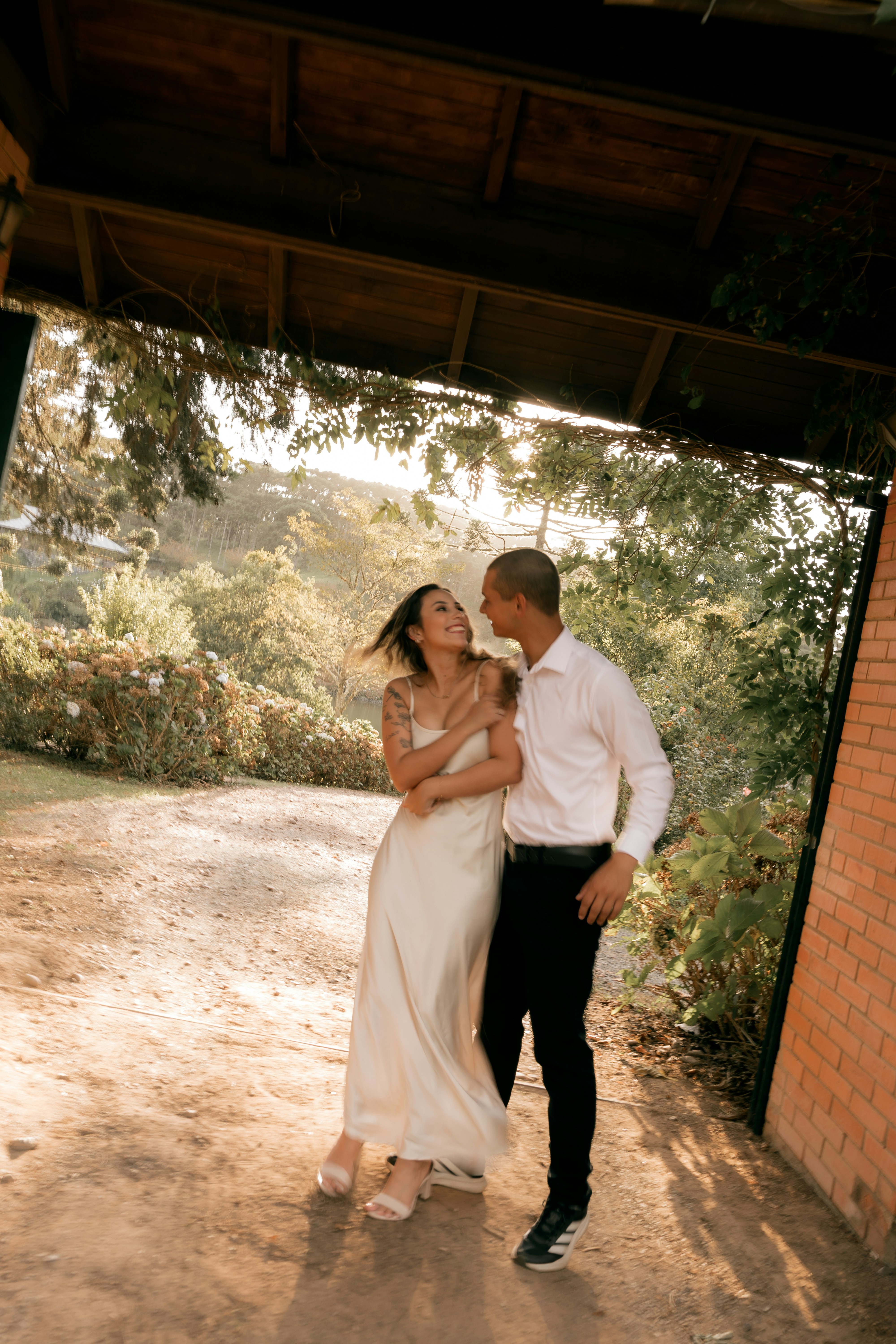 A couple walks together in a sunlit outdoor setting.