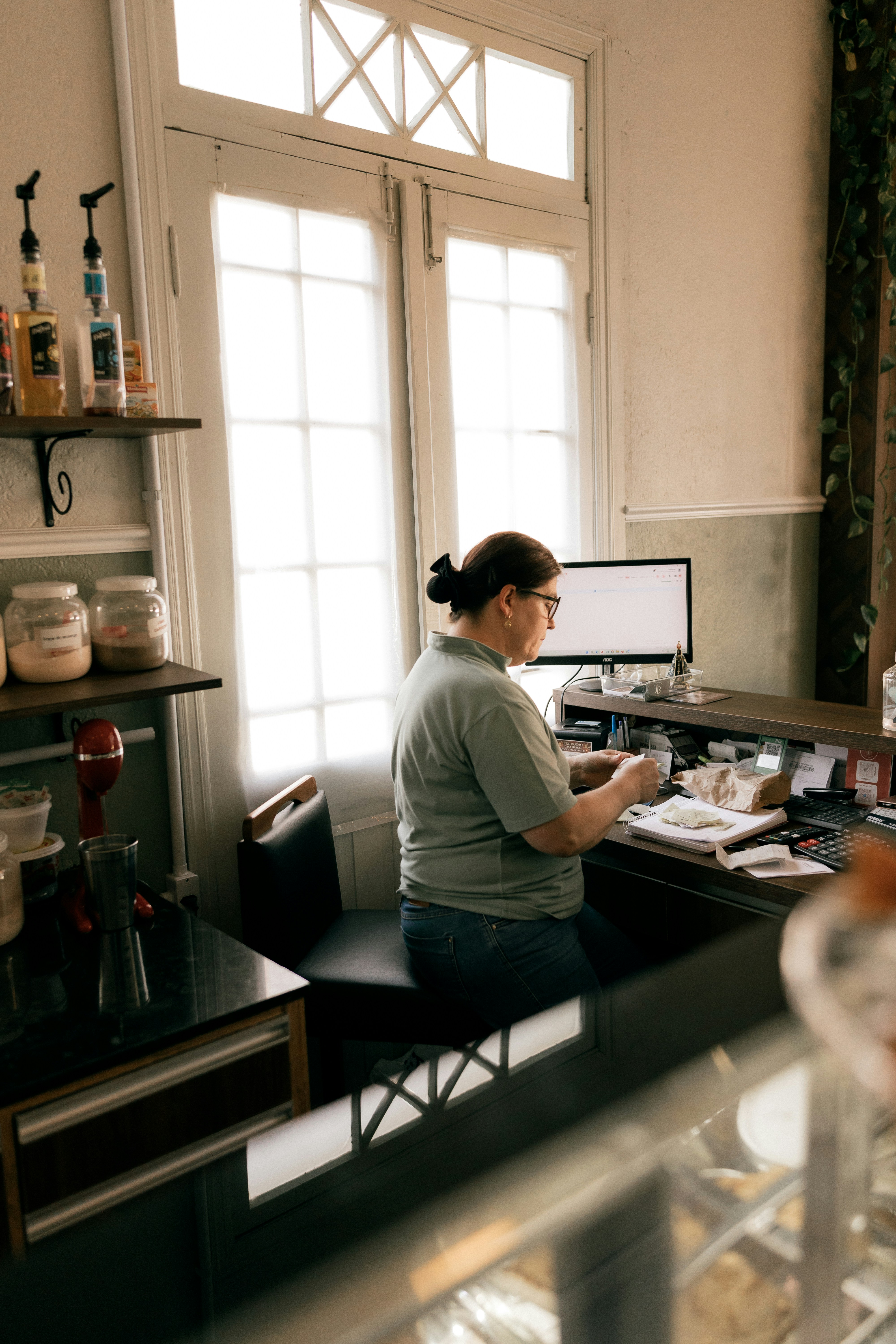 A woman working at a counter with a computer.