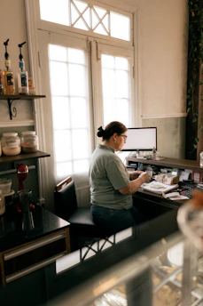 A woman working at a counter with a computer.