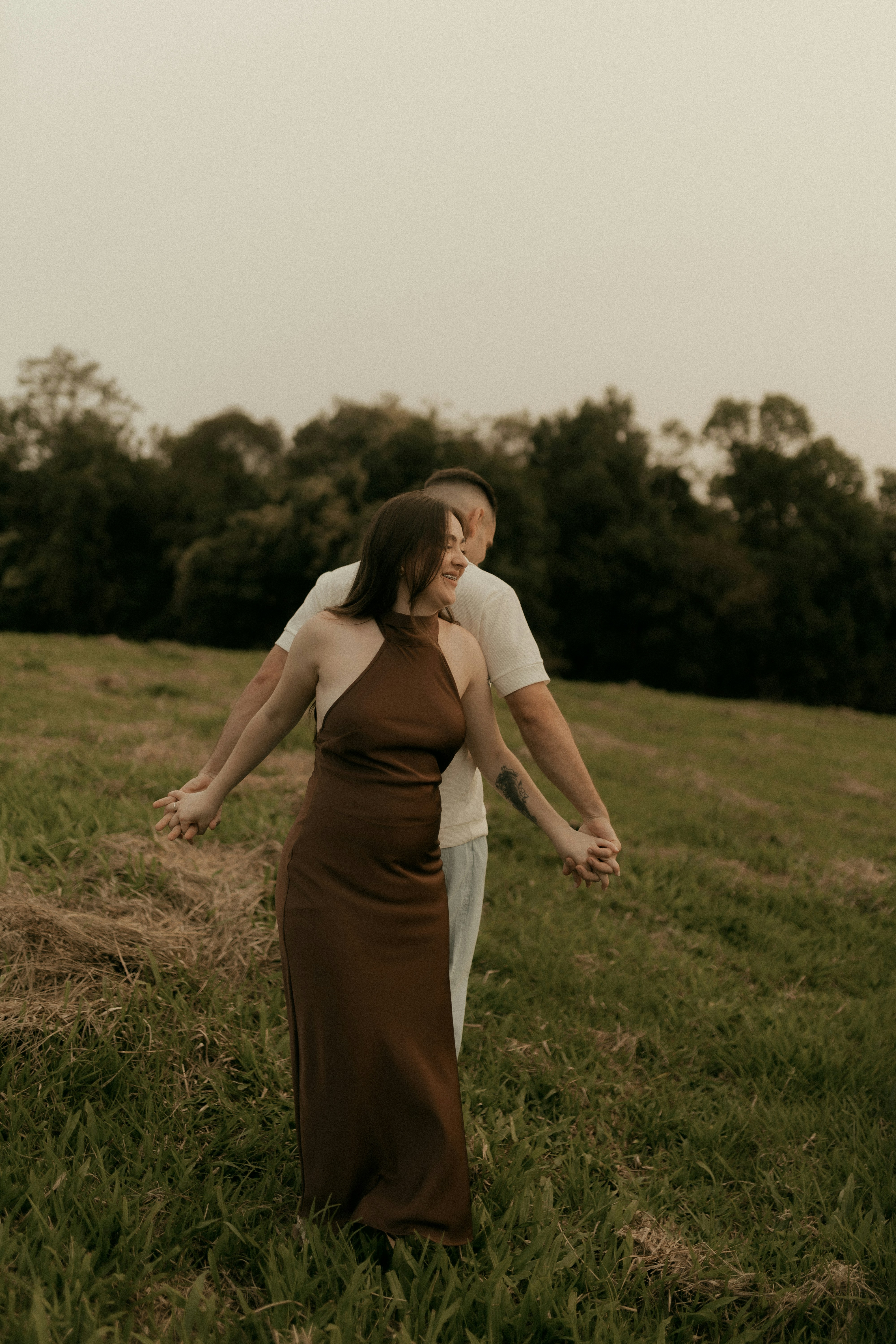 Couple holding hands in a grassy field
