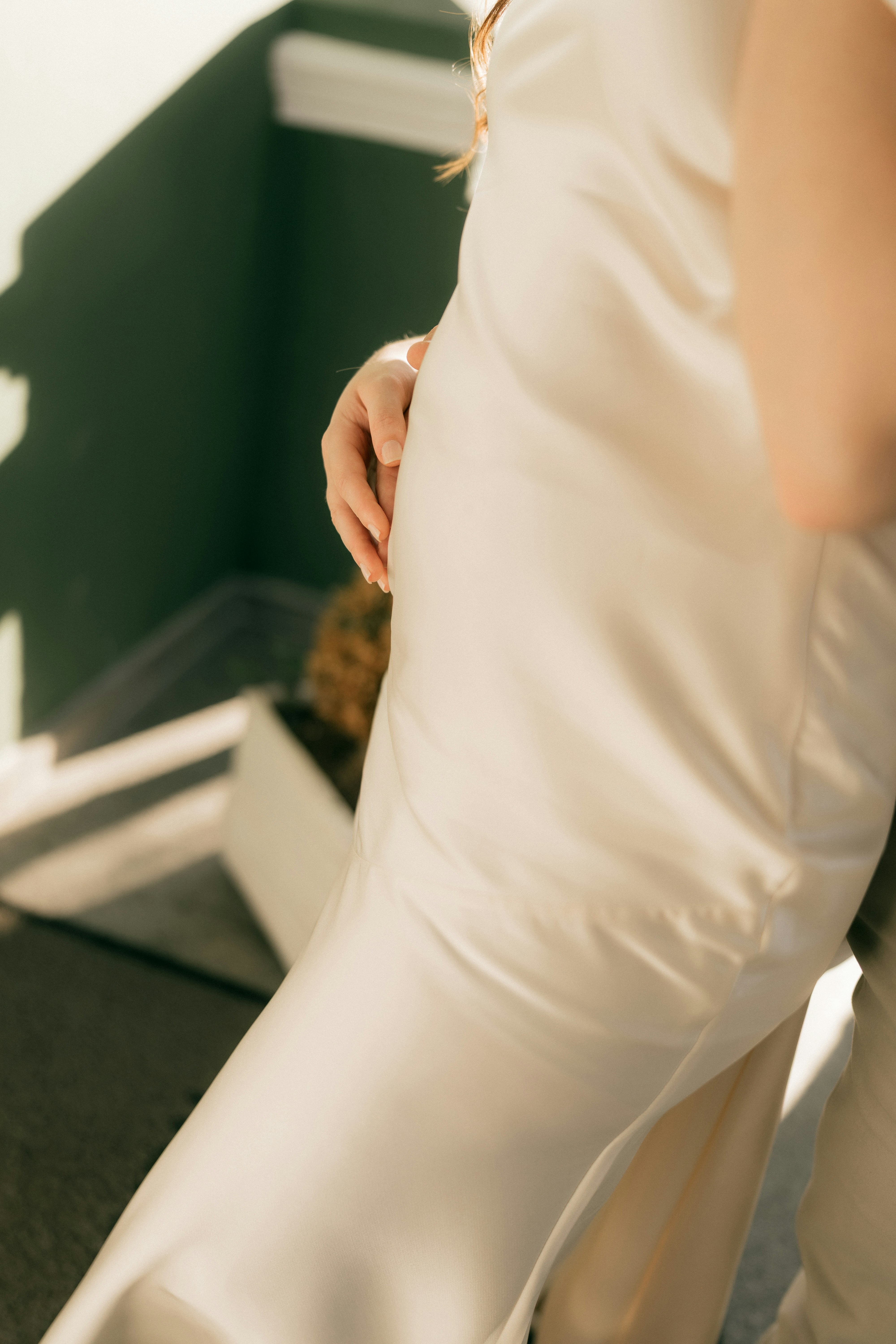 Femme en robe en satin crème dans les escaliers.