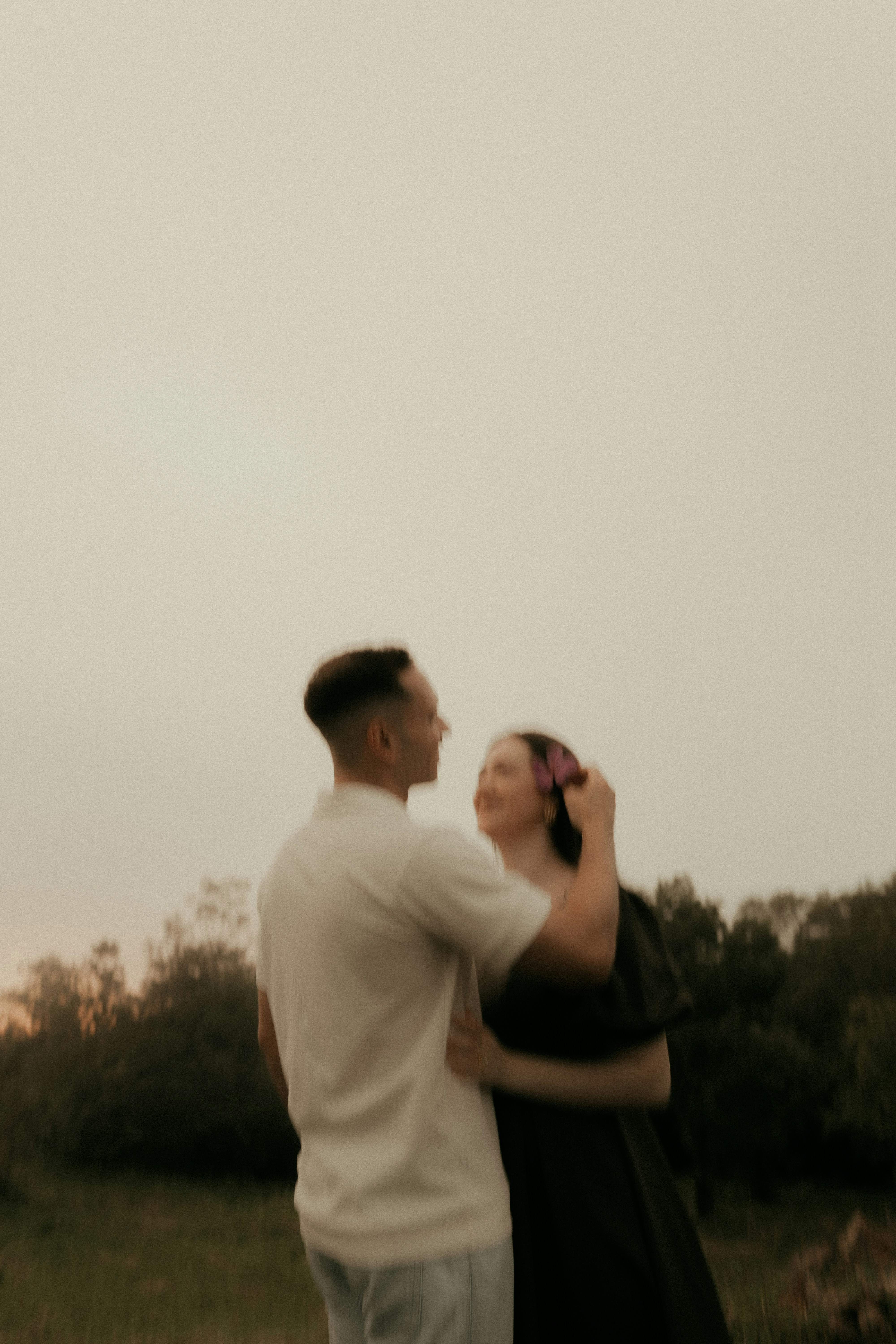 A couple embracing outdoors at dusk