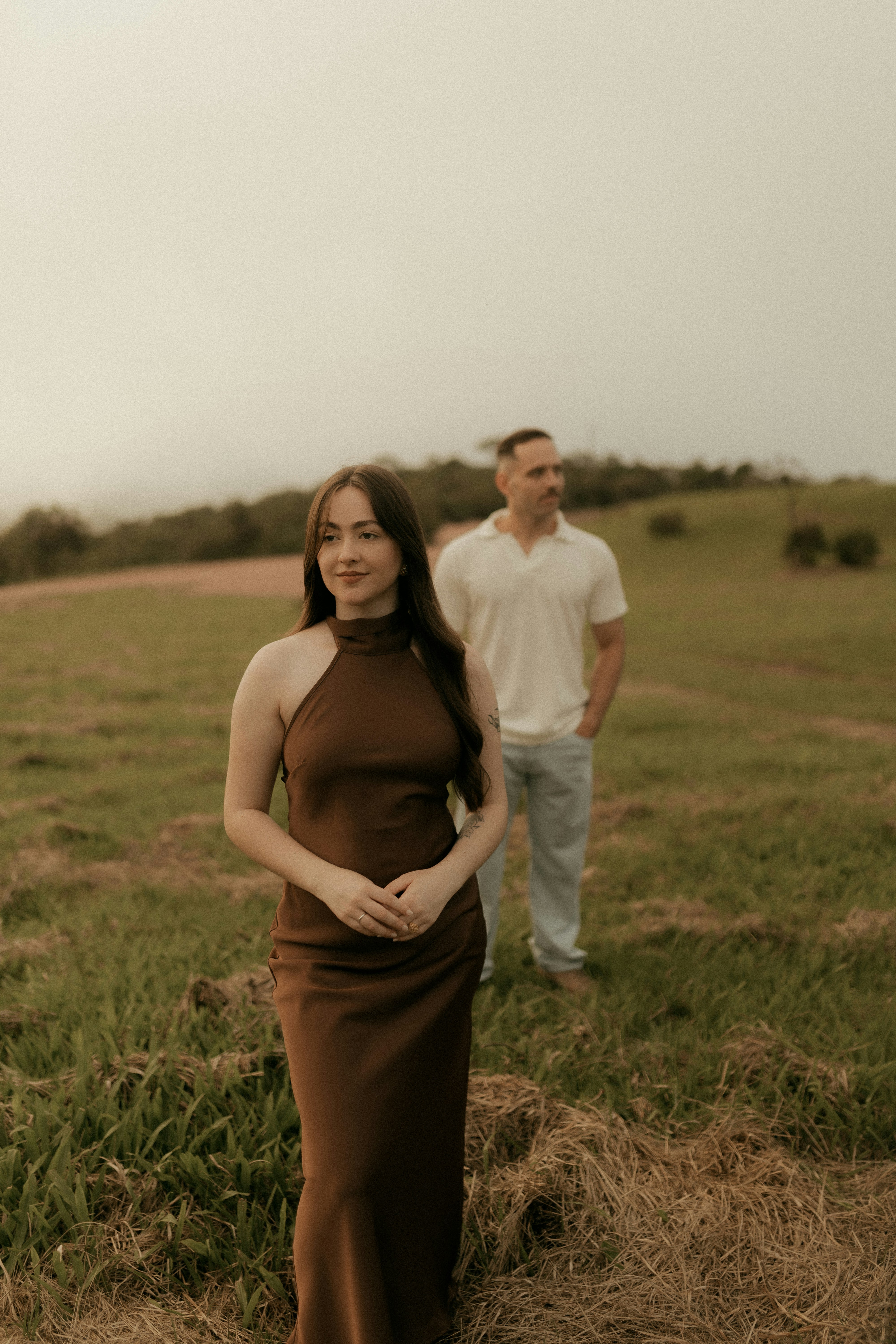 Couple standing in a grassy field outdoors