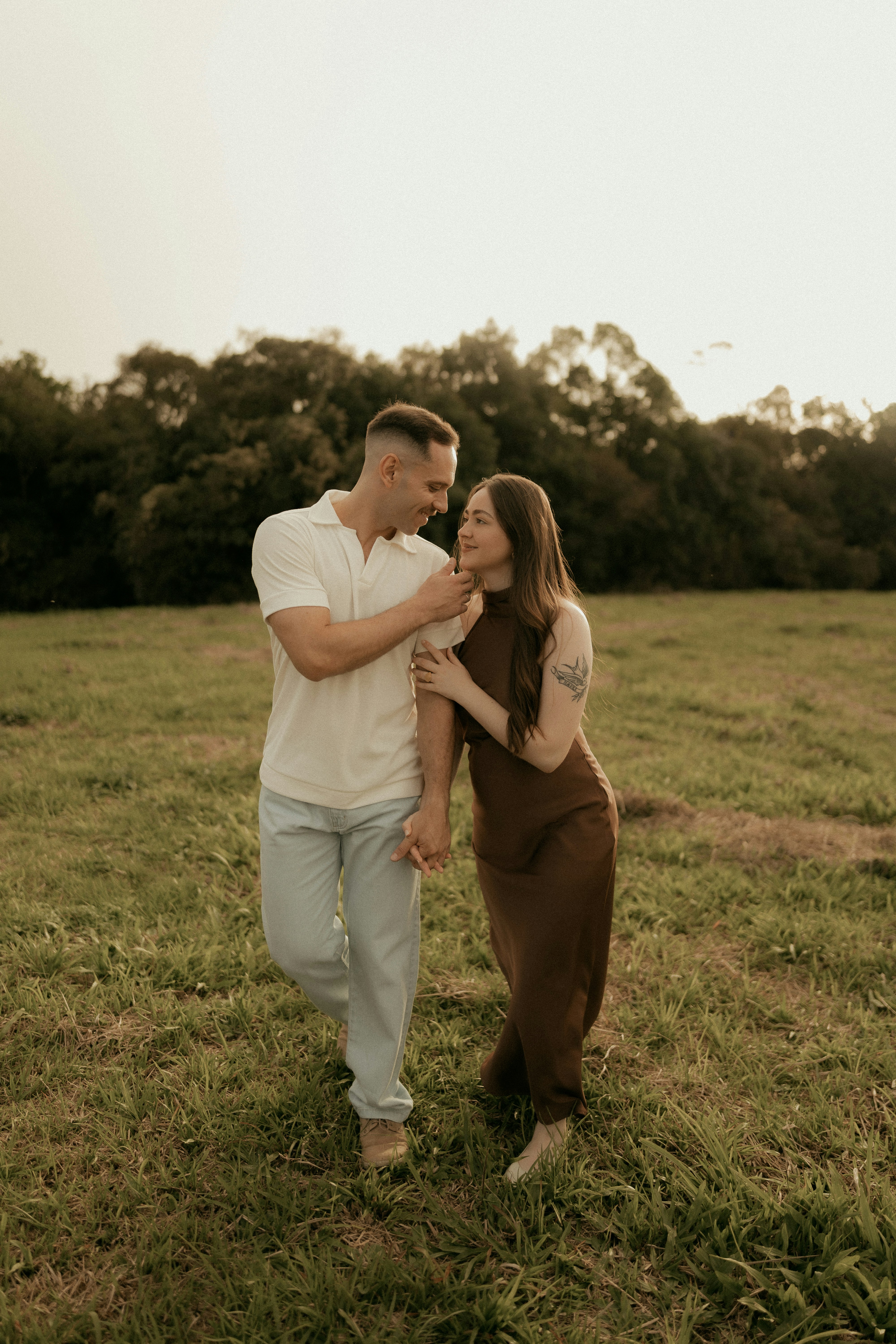 Couple walking together in a grassy field