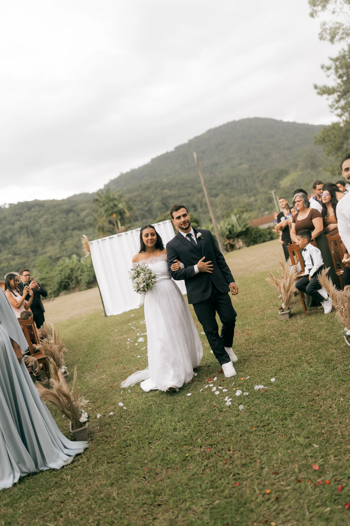 Bride and groom walking together in outdoor light showing the ceremony lighting conditions that depend on sun angle relative to the ceremony orientation and time of day