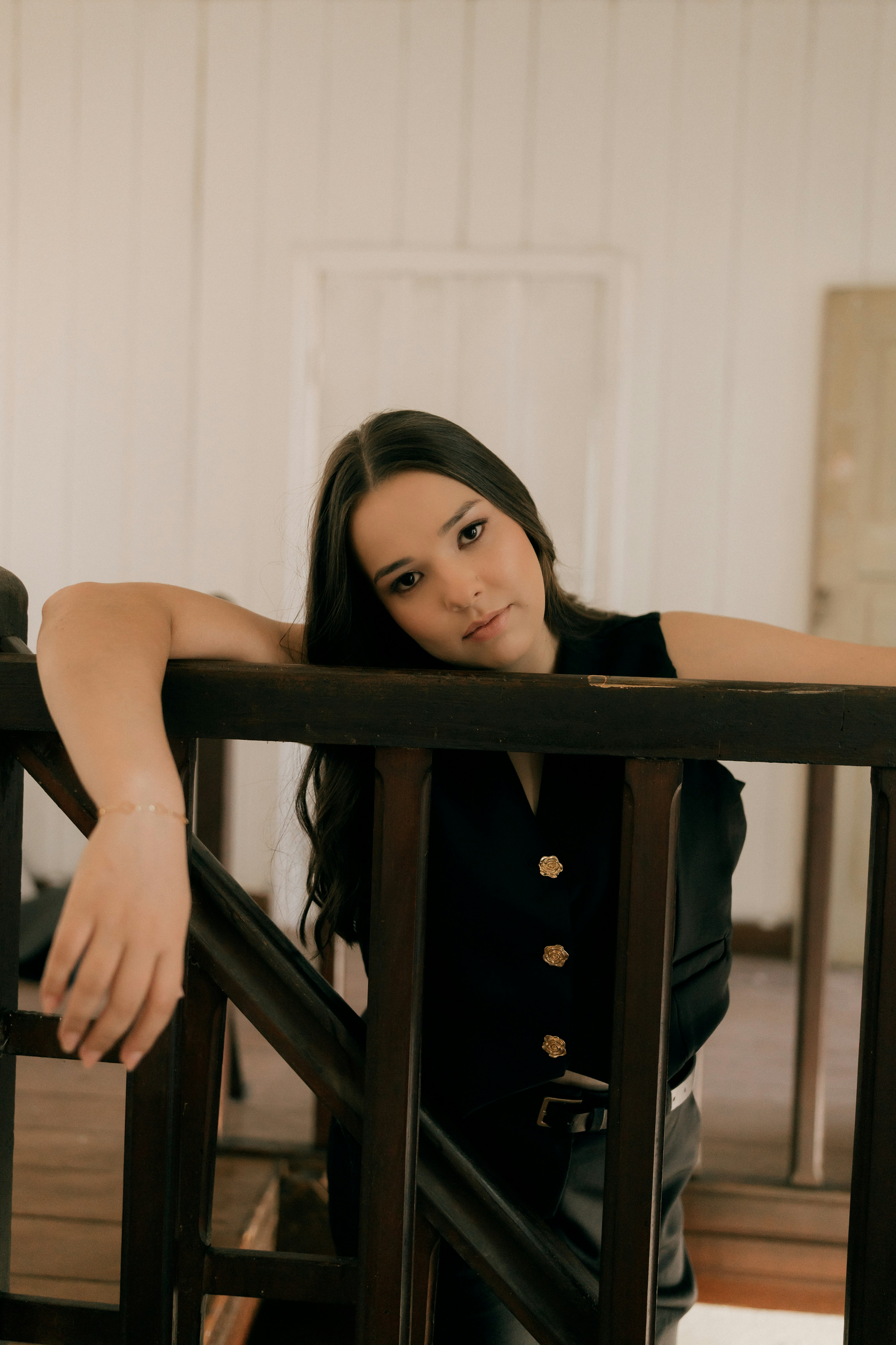 A young woman leans on a wooden railing