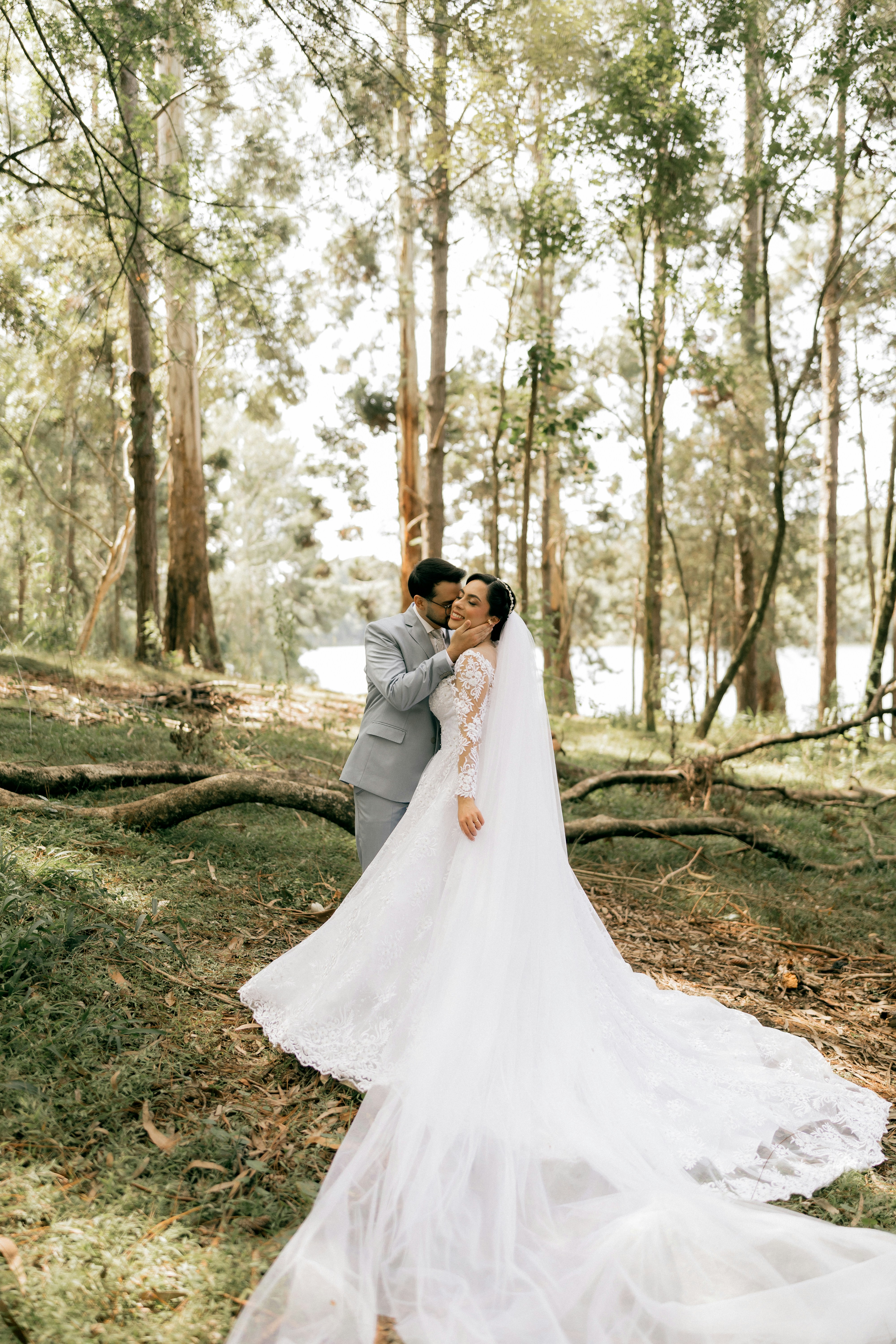 Bride and groom embracing in a sunlit forest