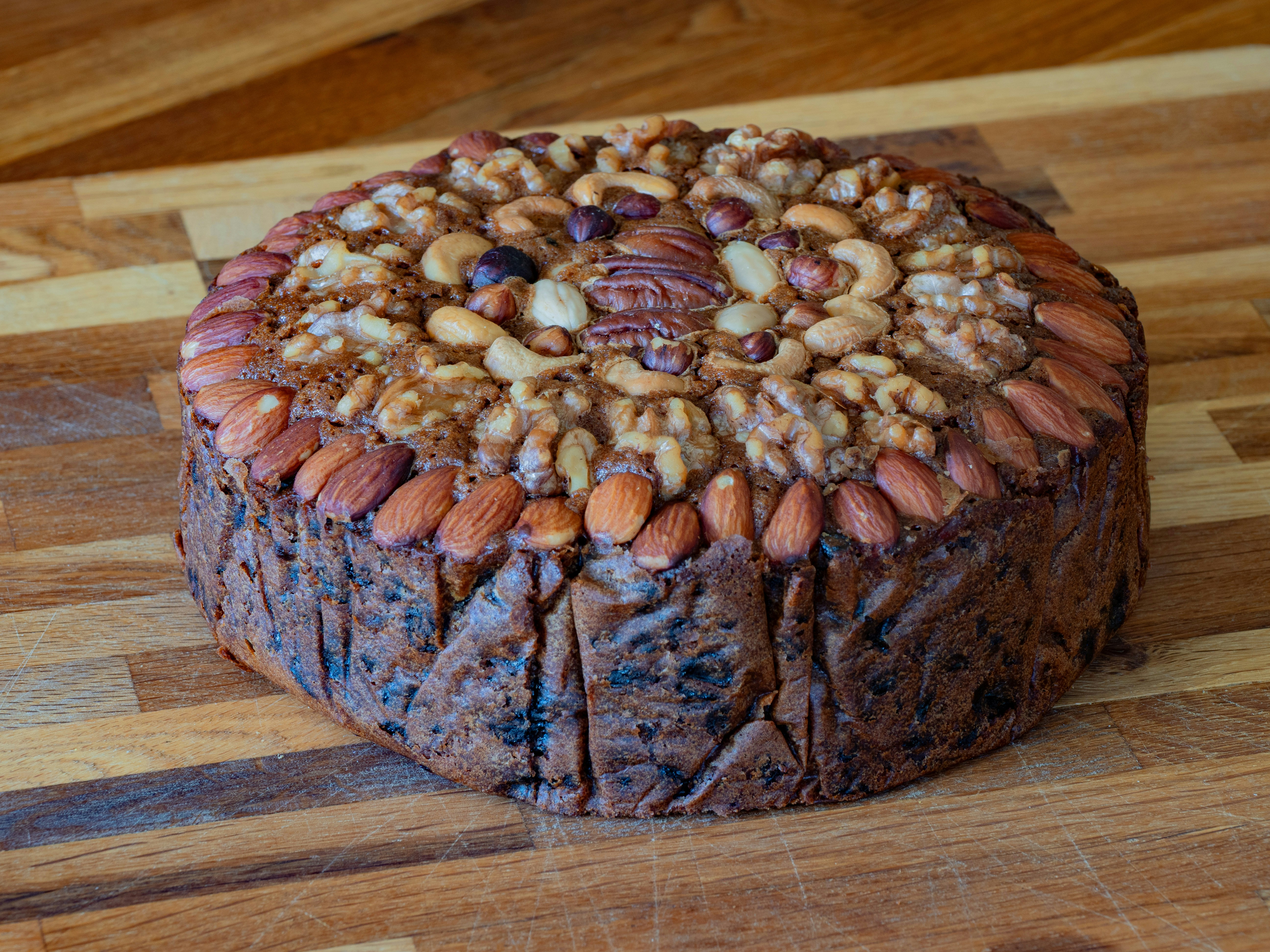 Bolo de frutas redondo decorado com várias nozes por cima