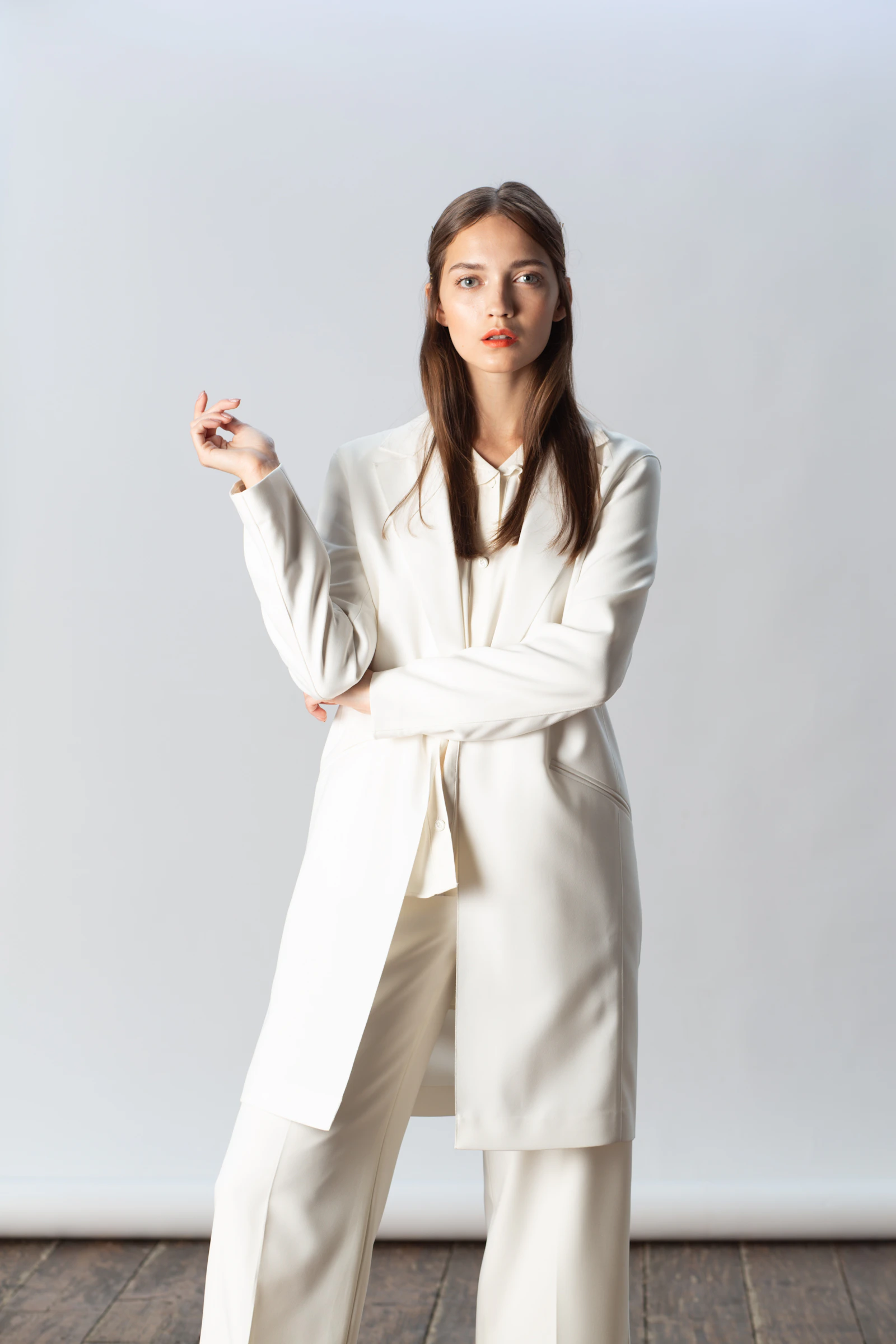 Fashion model in a clean white suit against a minimal background