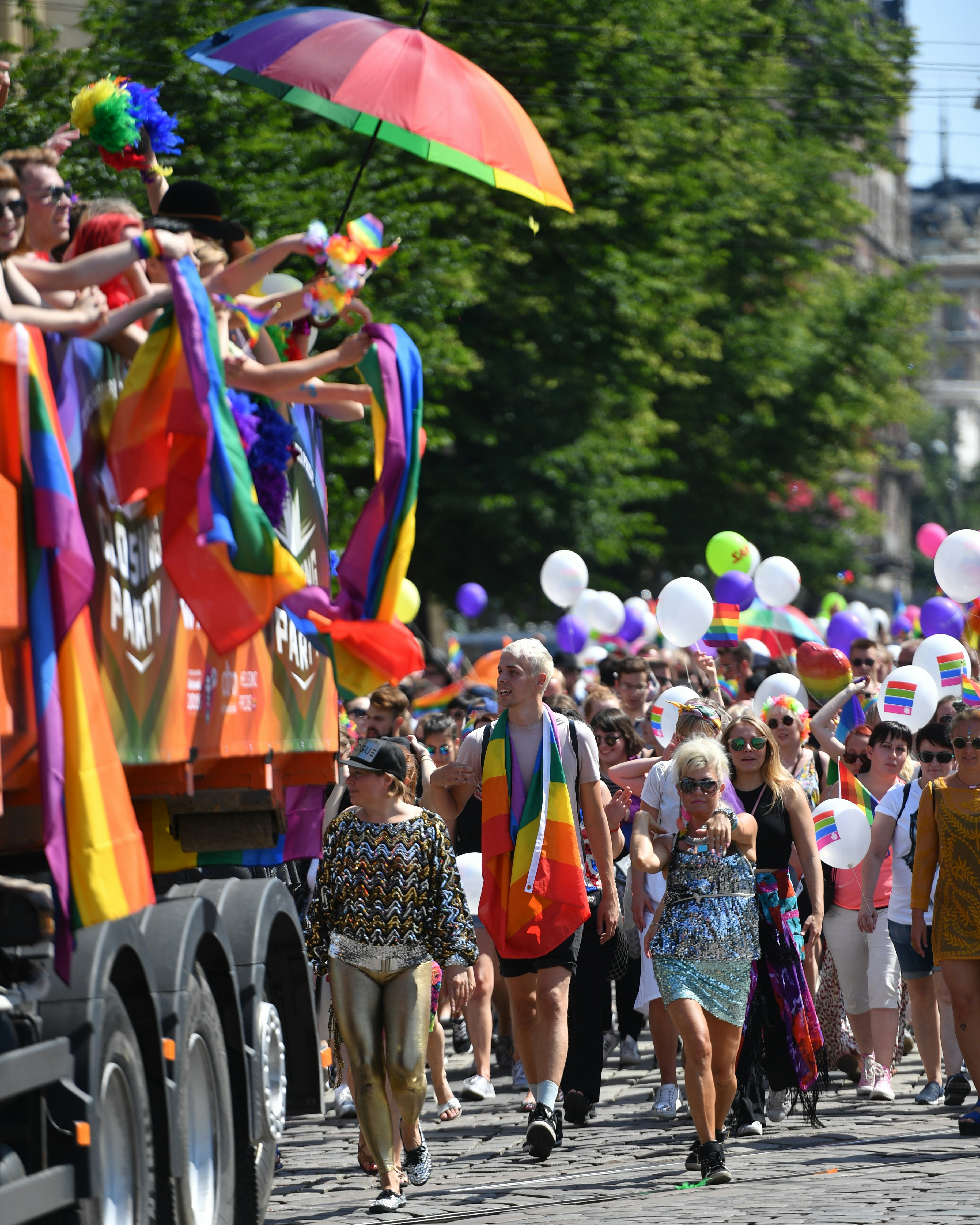 Die Leute feiern bei einer Pride-Parade mit Regenbogenflaggen