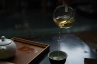 Tea being poured from a glass pot into a cup