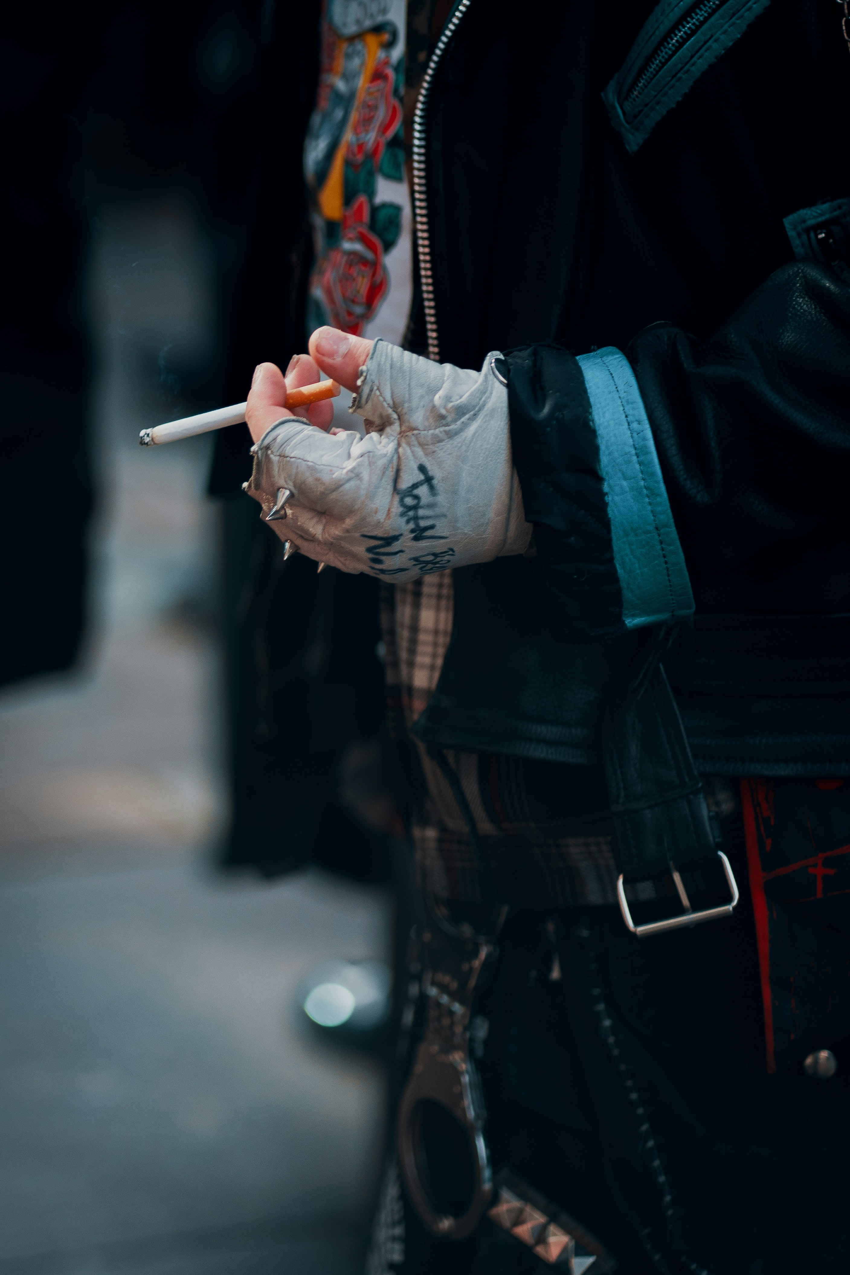 Persona sosteniendo un cigarrillo encendido con vendas en mano.