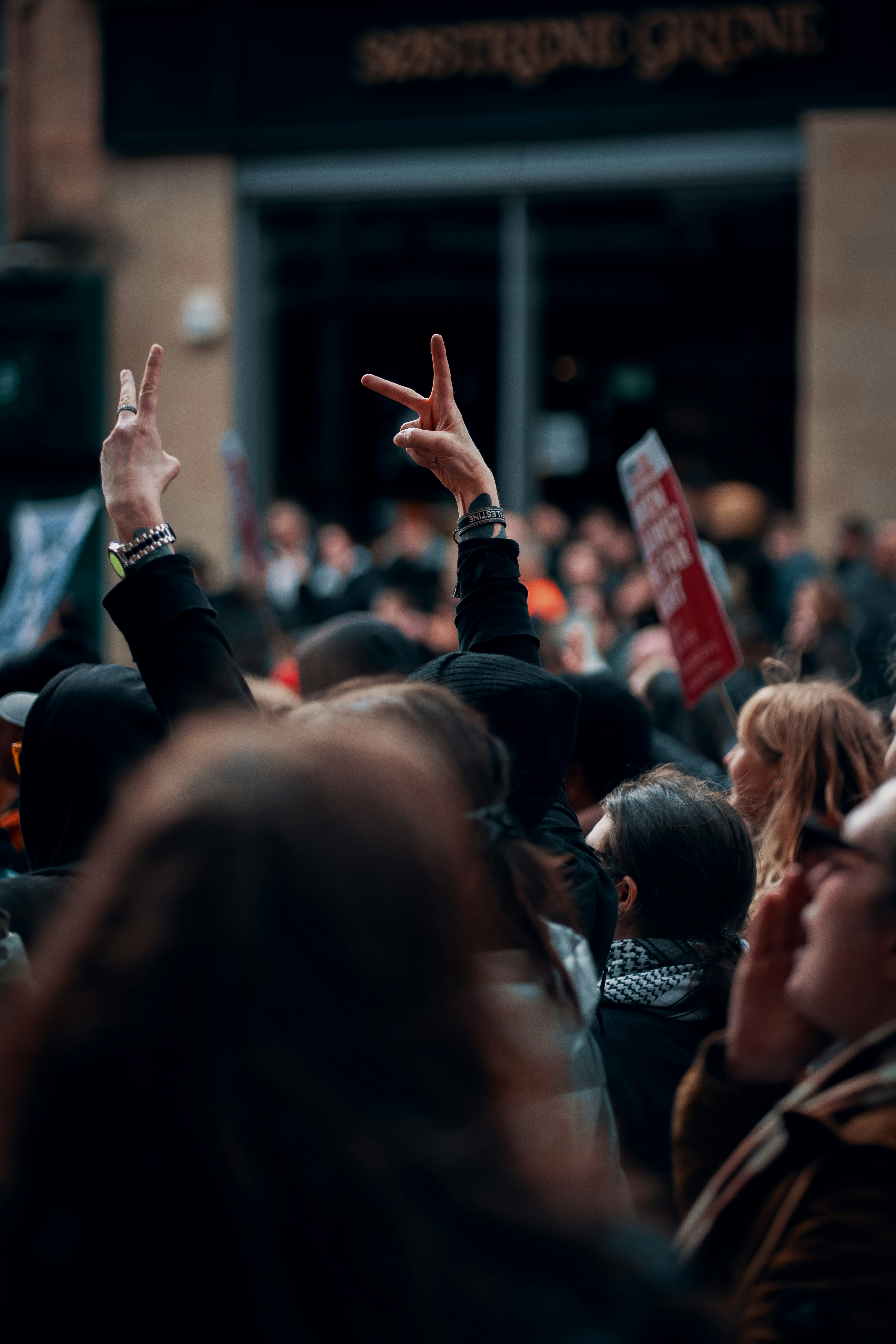 Multitud con las manos levantadas en signos de paz