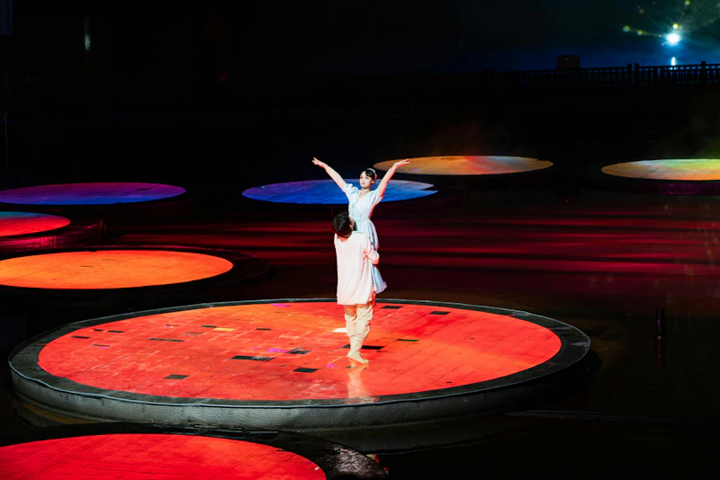two dancers performing on illuminated stages