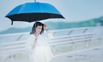 Woman holding a blue umbrella in the rain