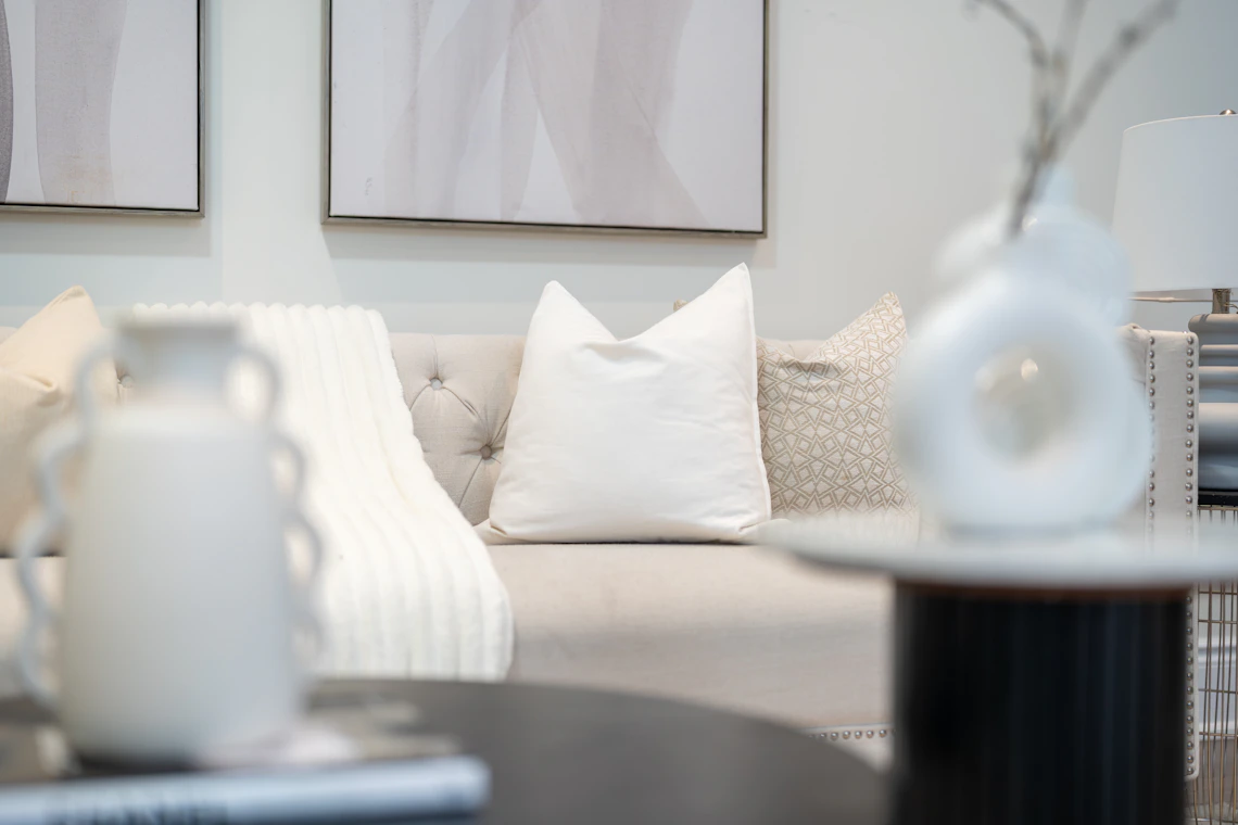 Neutral modern living room with sofa, coffee table, lamp, and home decor