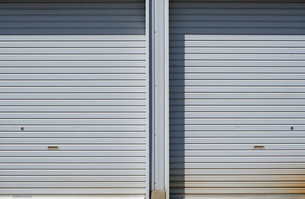 Dos cortinas metálicas enrollables en galpón industrial