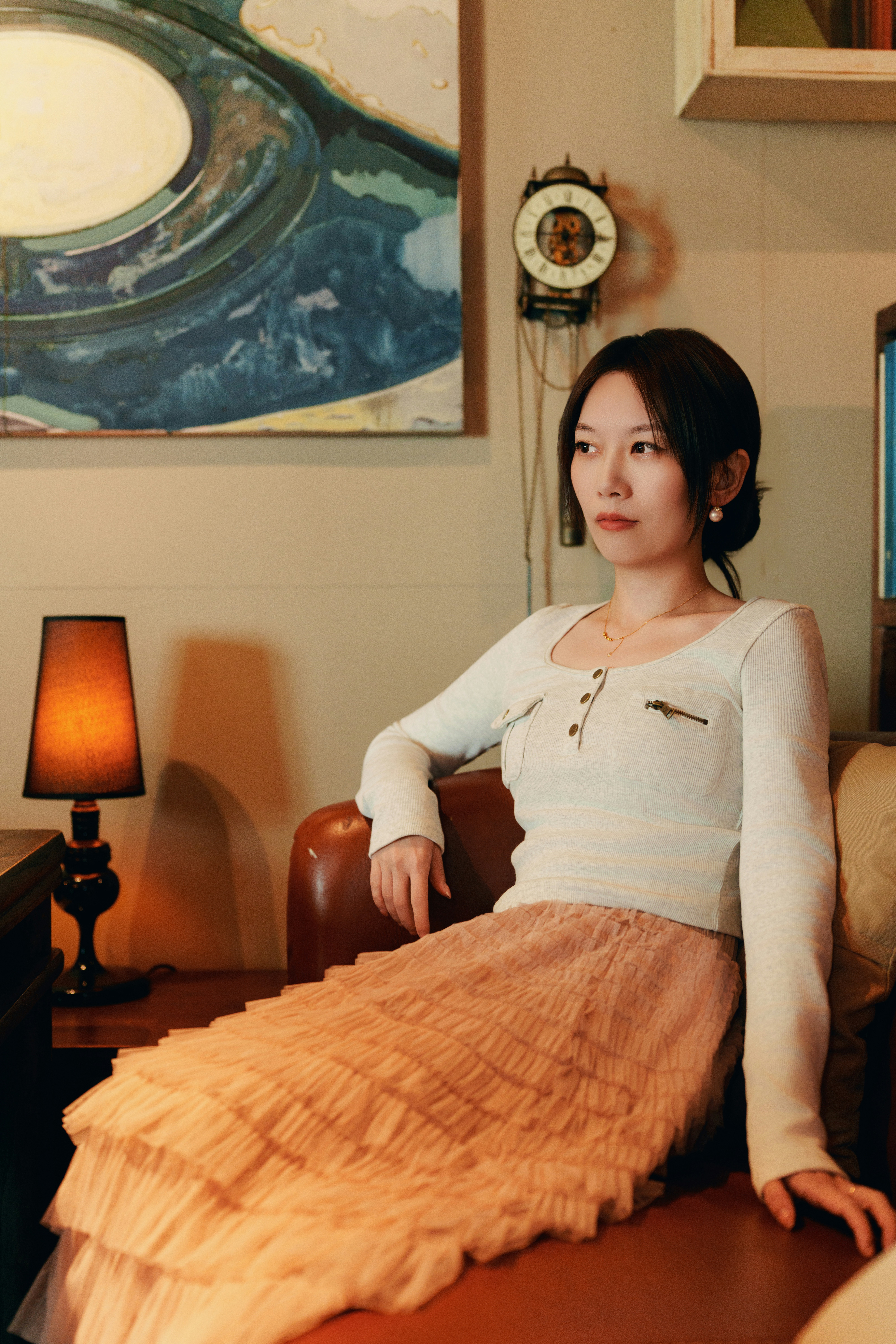 スカートを履いた女性がソファに座っている。