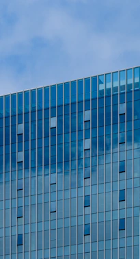 Modern building with blue glass facade and sky