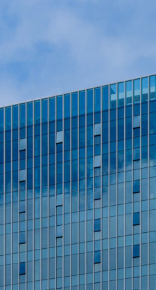Modern building with blue glass facade and sky
