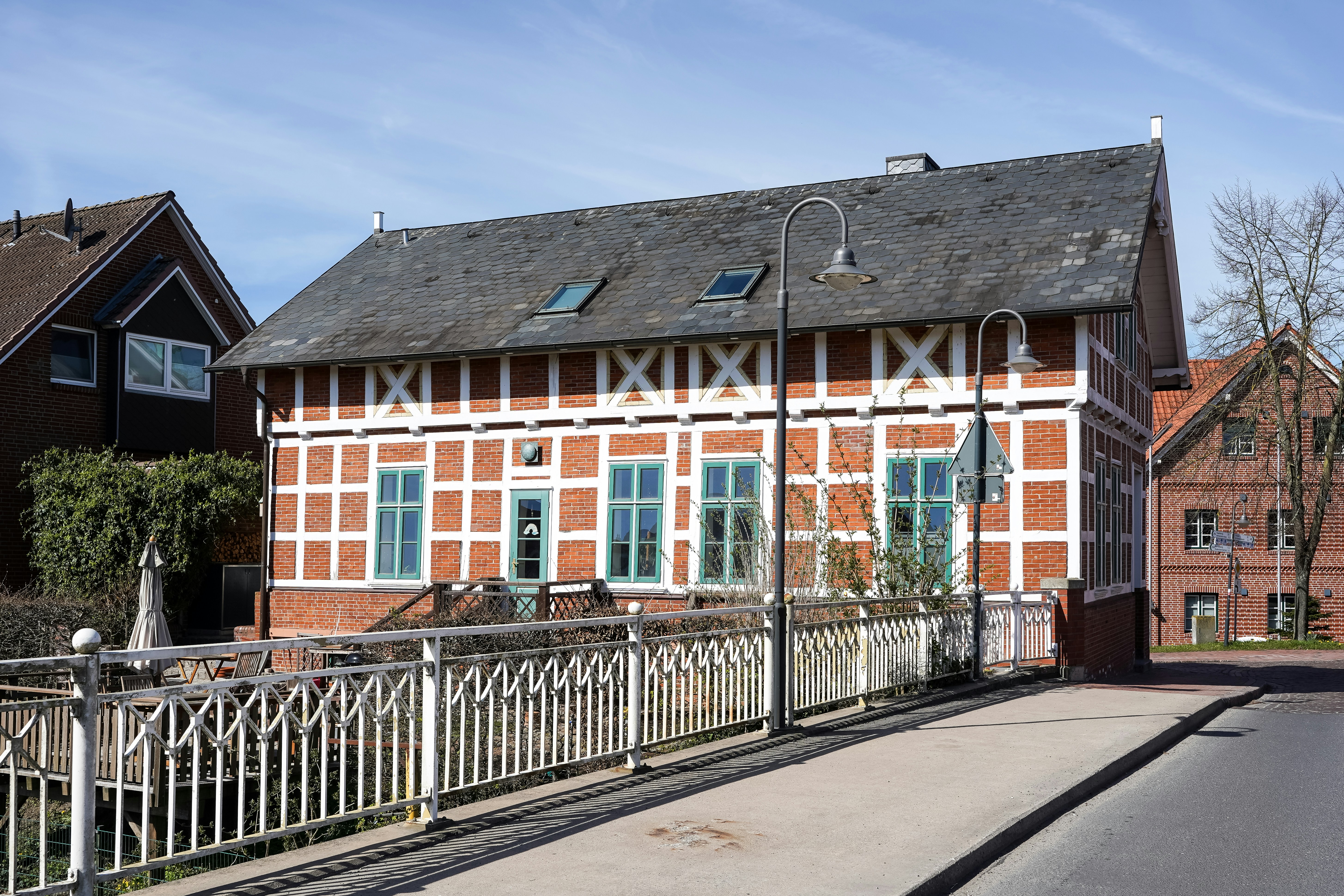 Half-timbered house with blue windows and white railing.