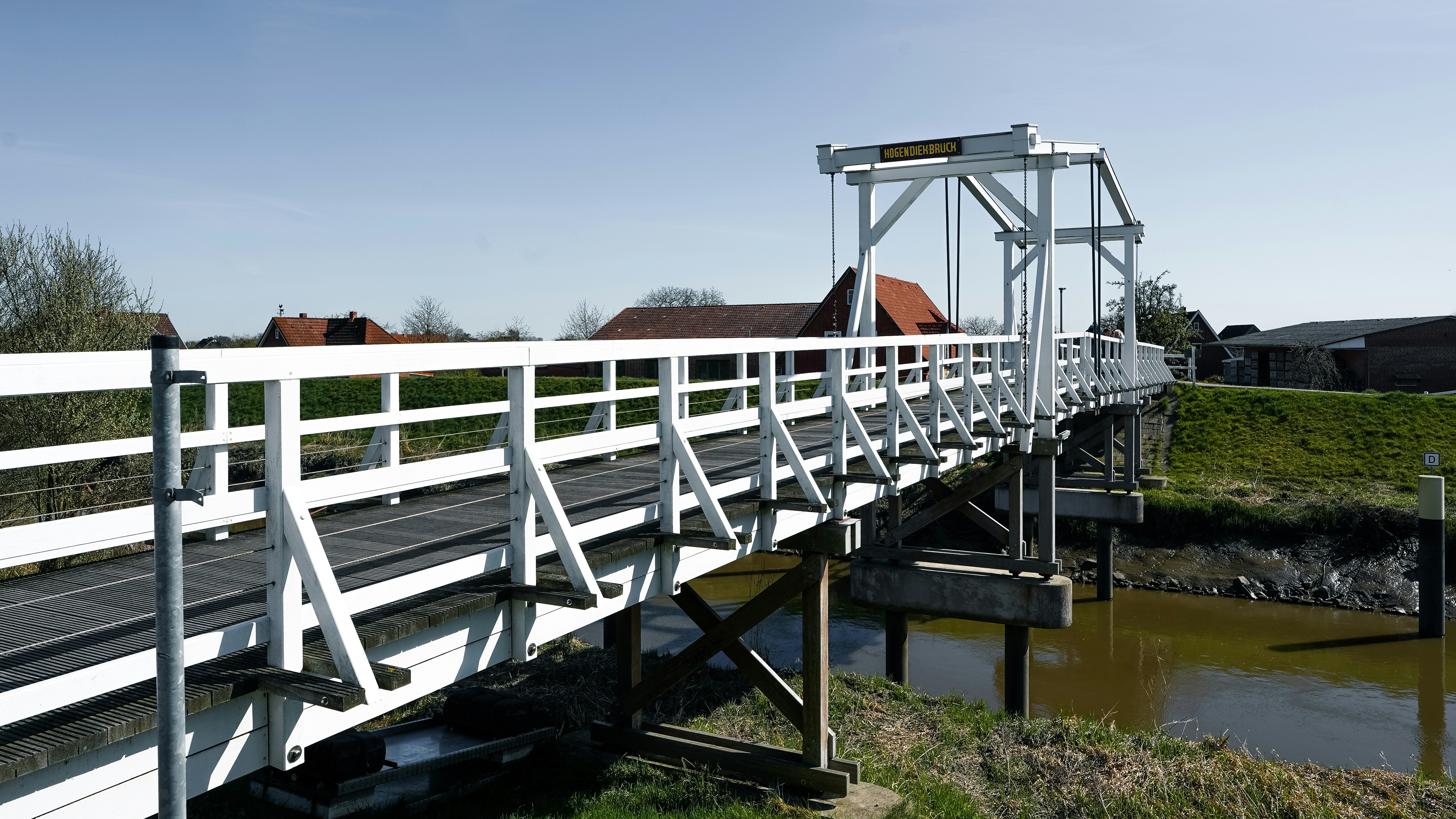 A white drawbridge over a calm waterway.