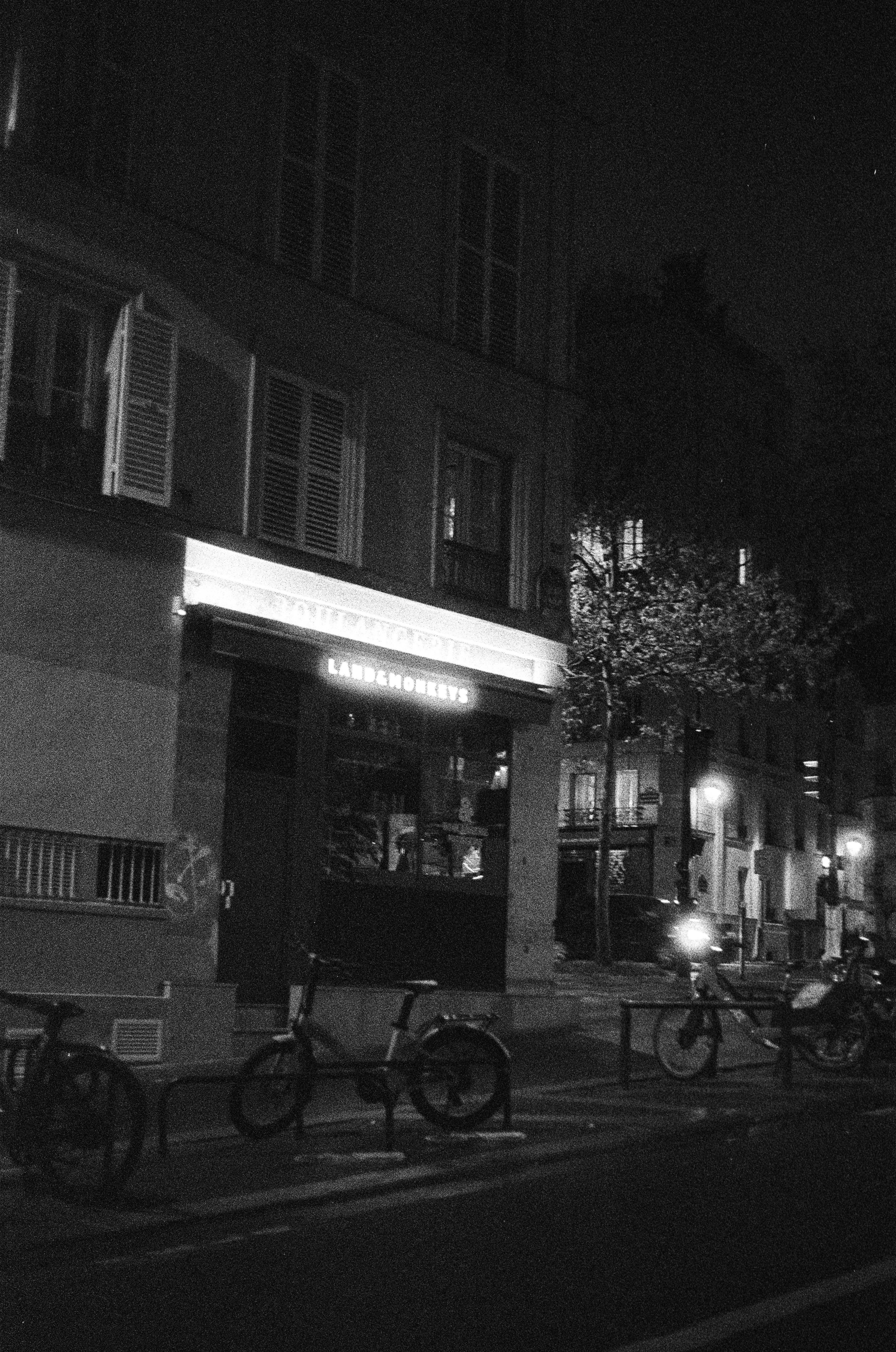 Pemandangan jalanan di malam hari dengan bangunan dan sepeda