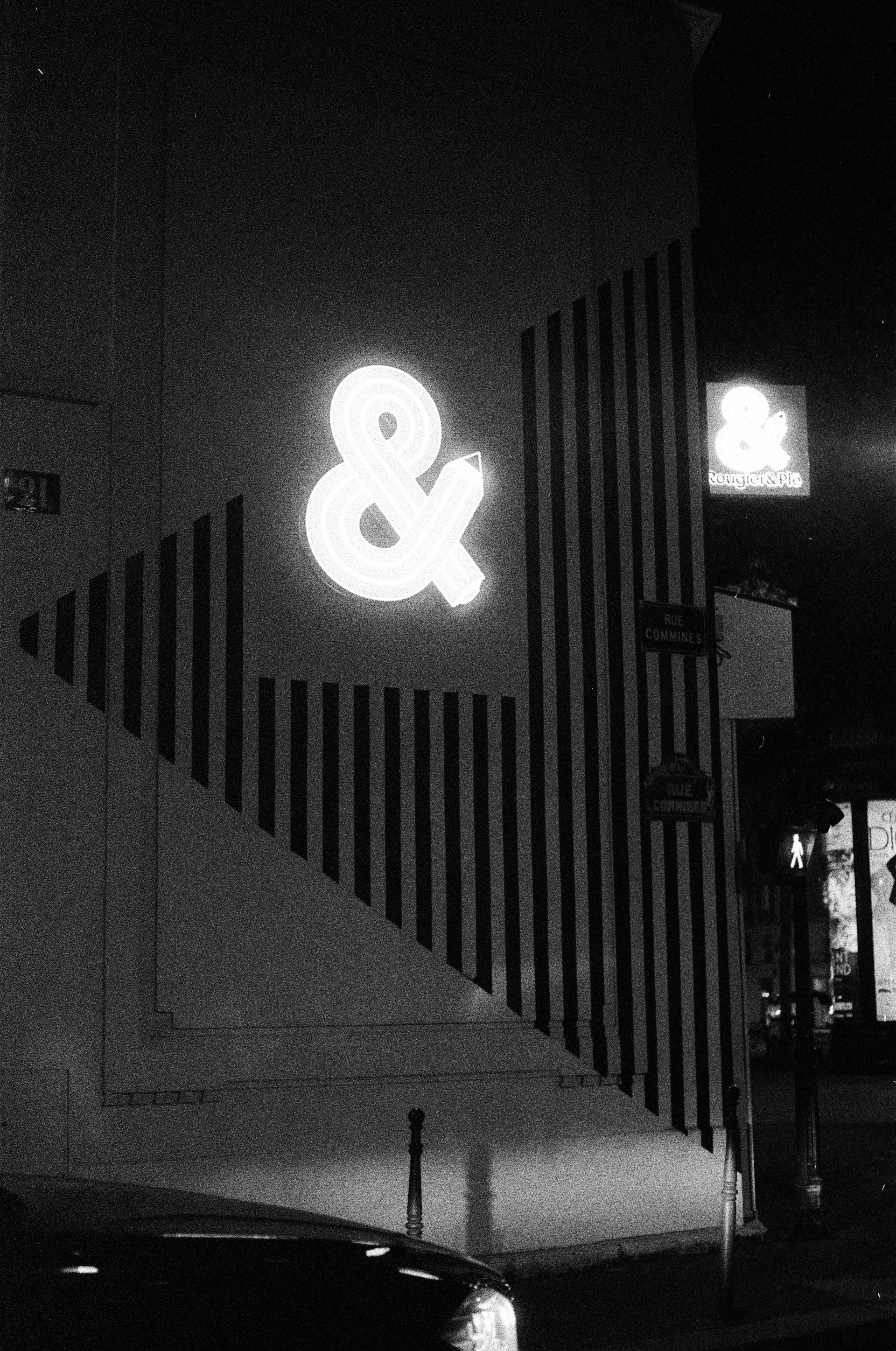 Neon ampersand sign on a building at night