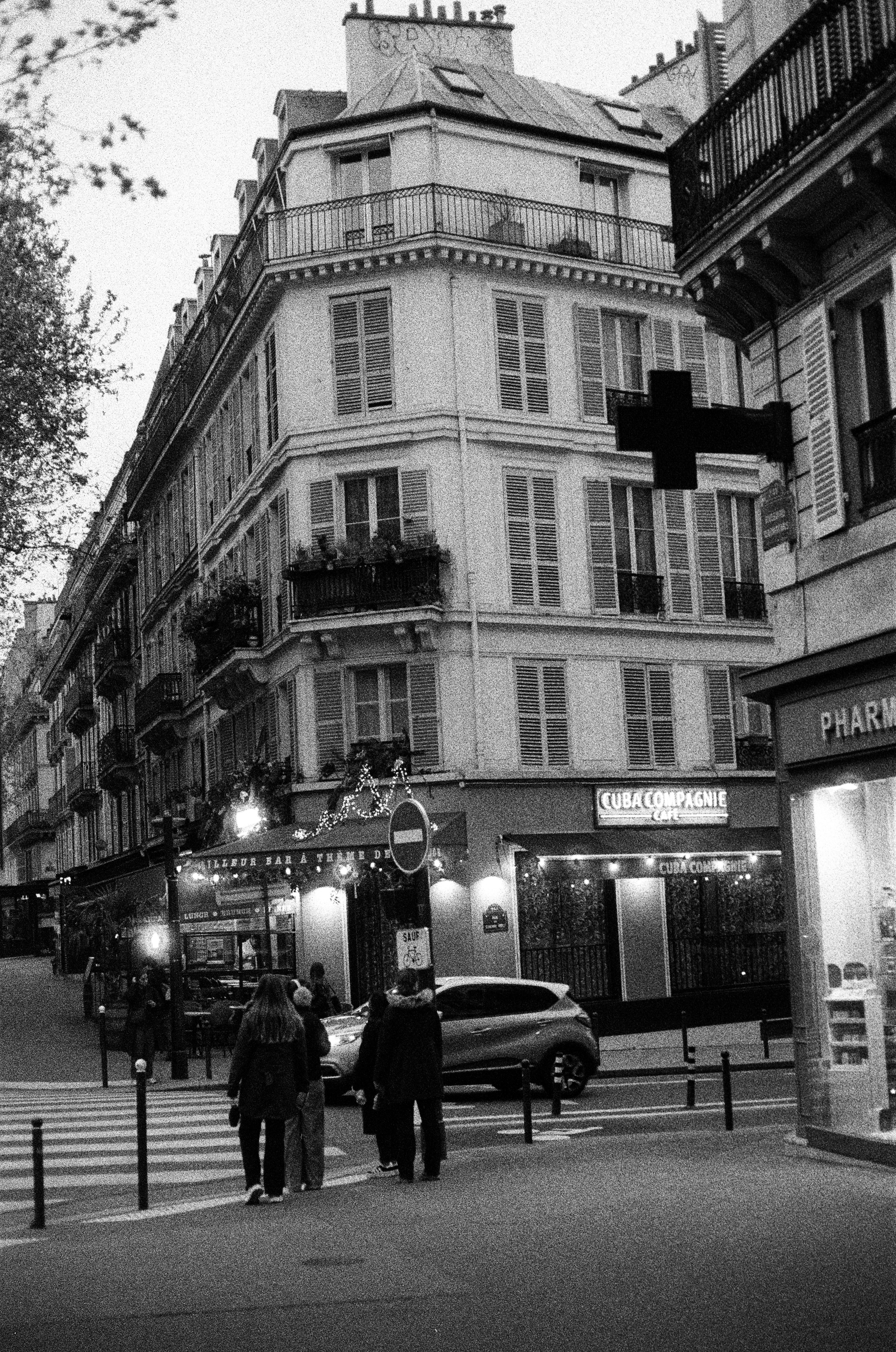 Orang-orang menyeberang jalan di depan gedung-gedung Paris