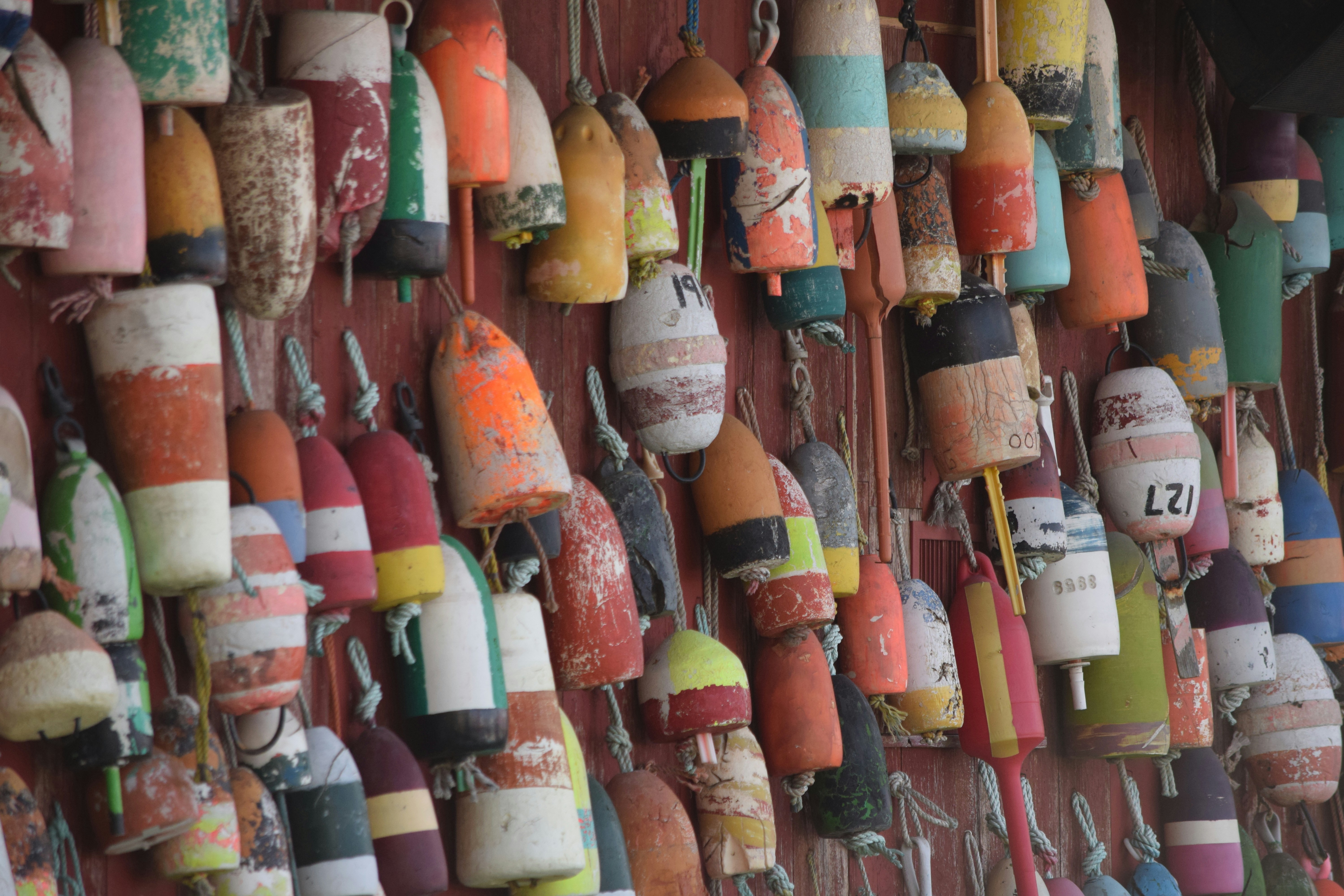 Collection of colorful fishing buoys hanging on a wall