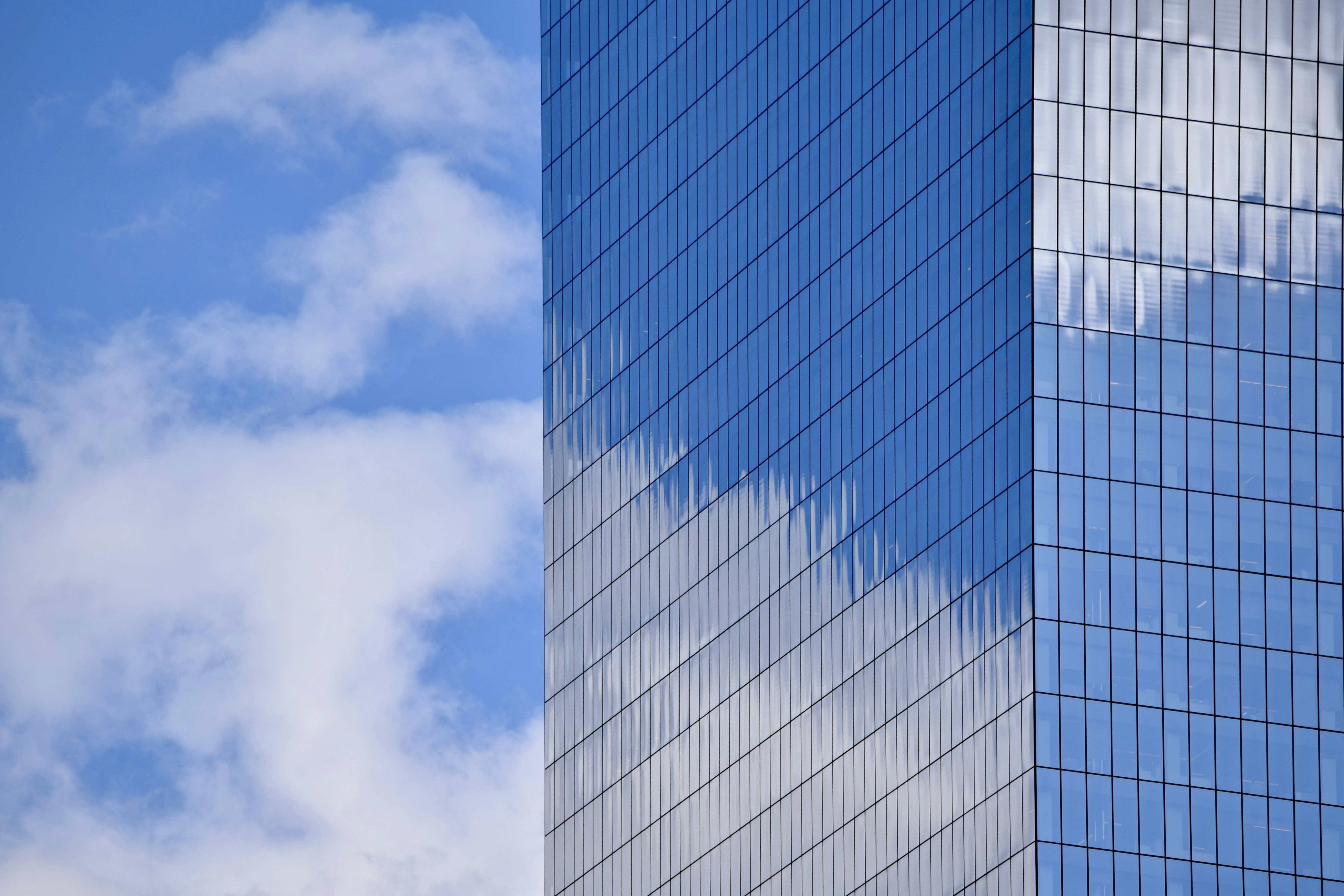 Clouds reflected on a modern glass skyscraper