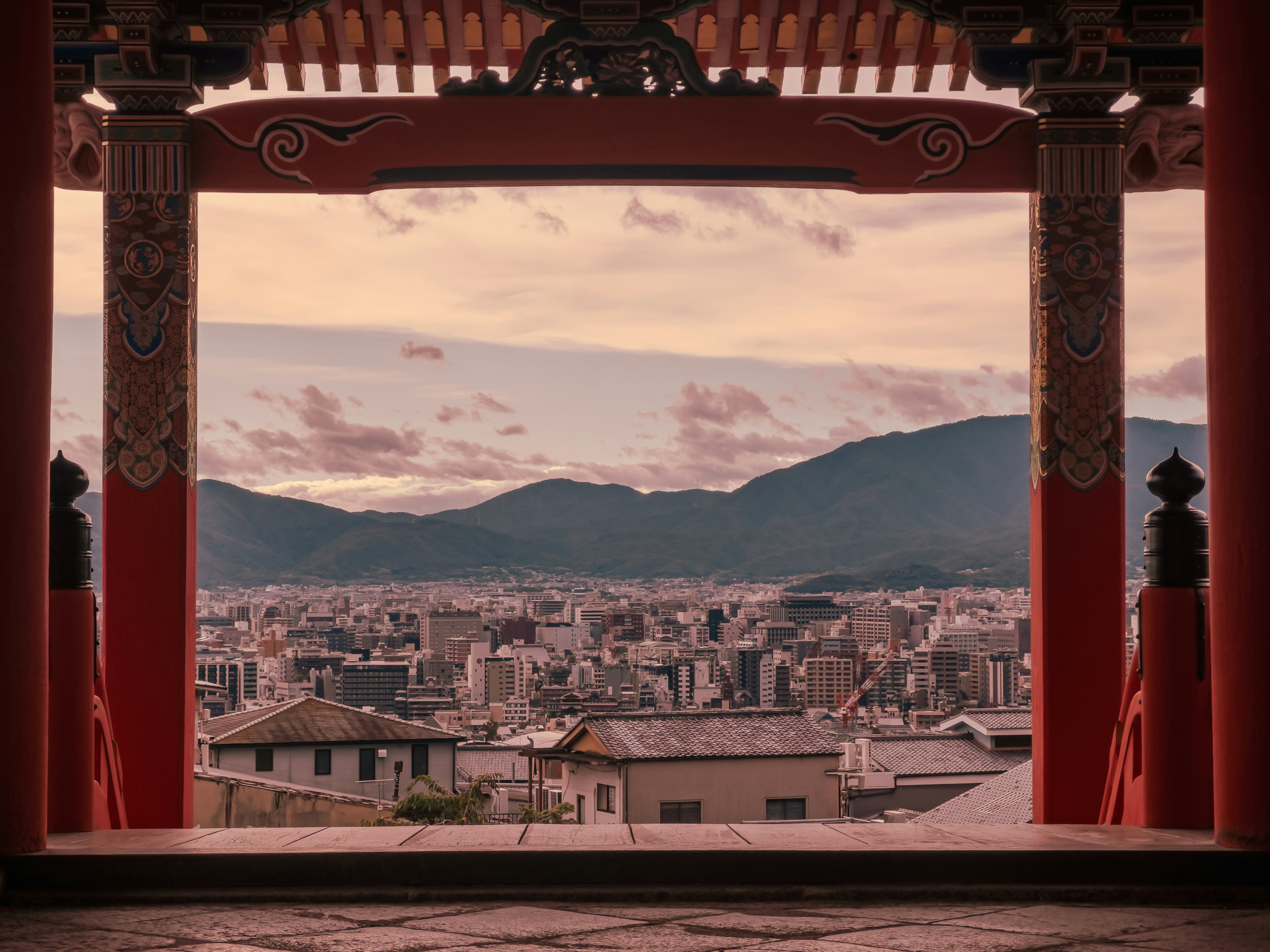 View of a city skyline framed by traditional japanese architecture.