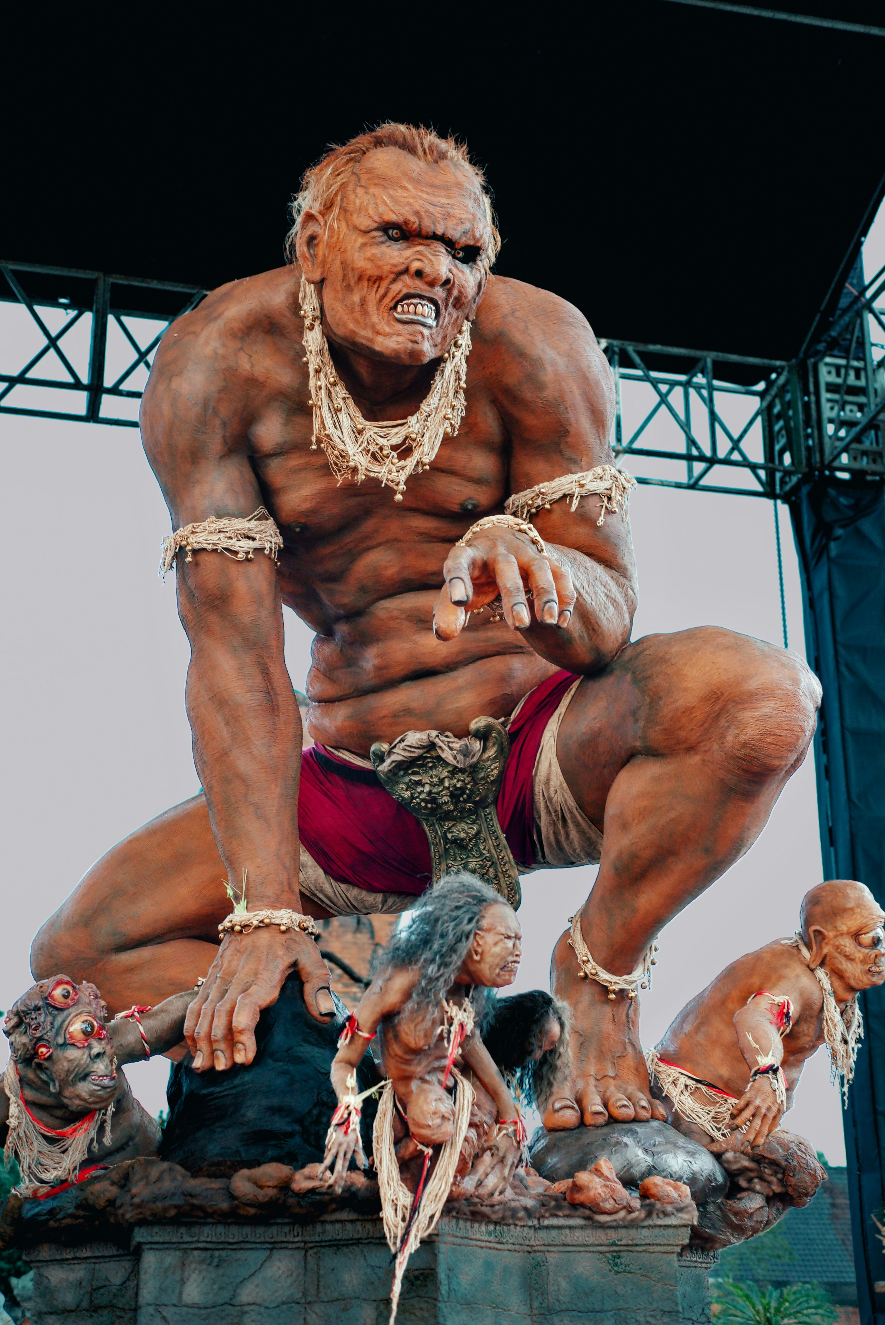 Giant ogre statue with smaller figures at its feet
