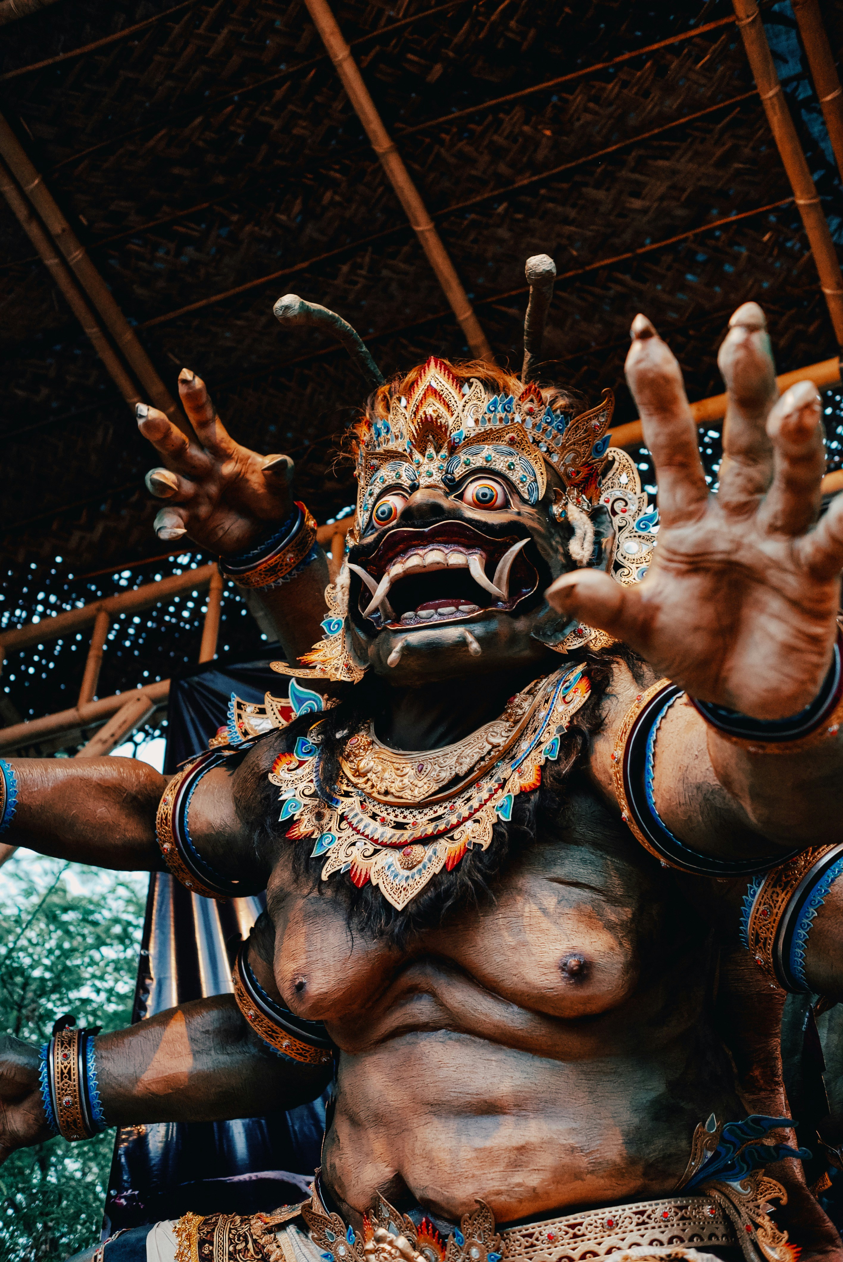 A performer in a detailed, ornate costume with multiple arms
