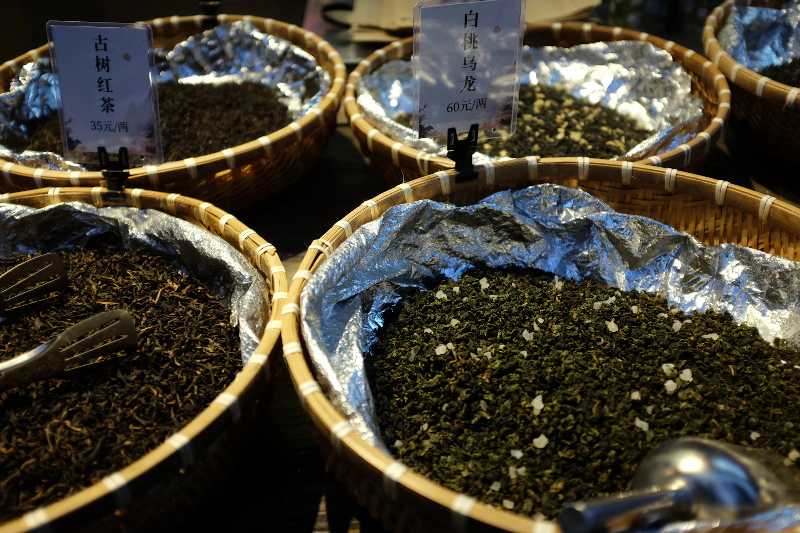 Cestas con distintas variedades de té y hojas secas exhibidas para su venta