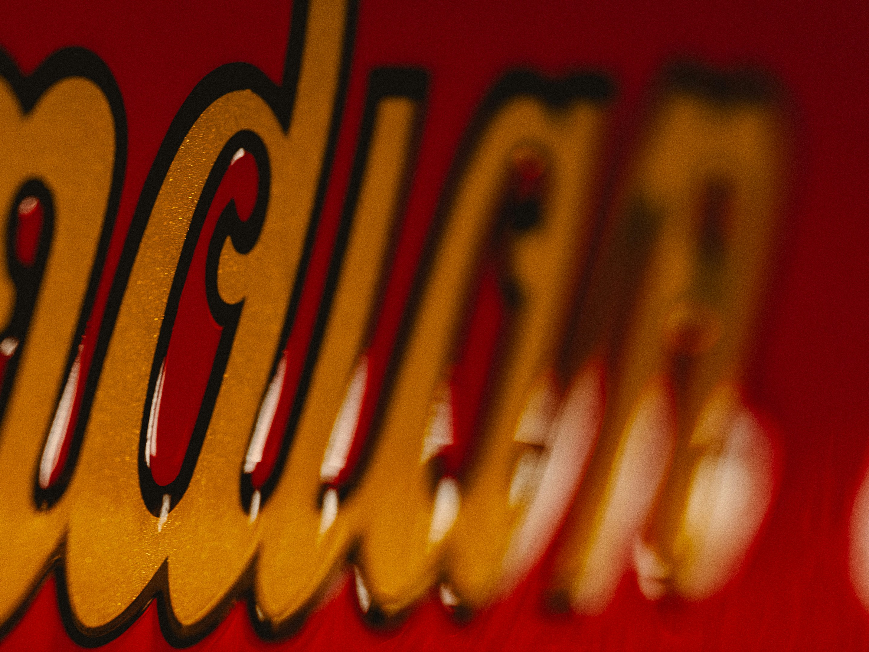 Close-up of a red sign with gold lettering