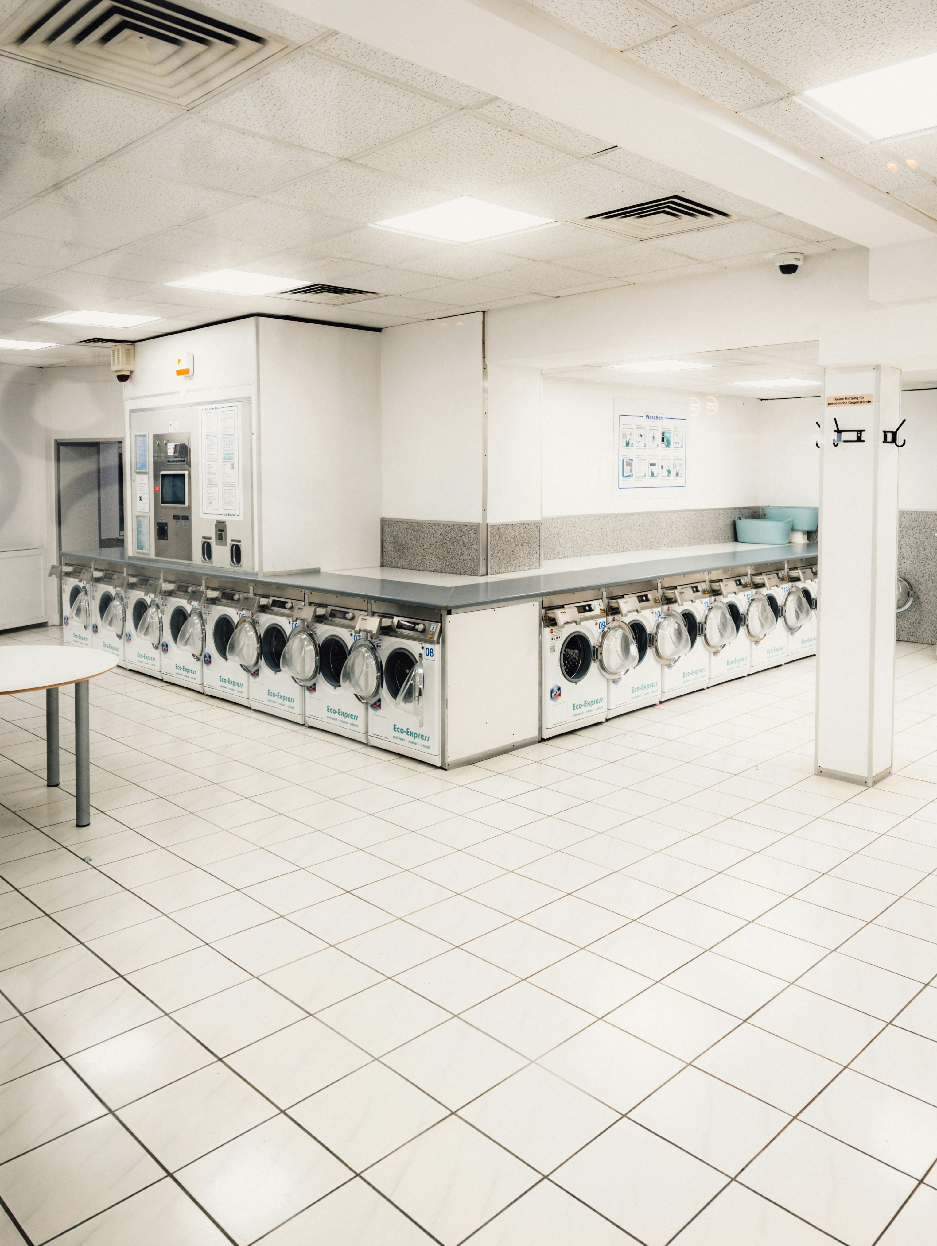 Row of washing machines in a brightly lit laundromat