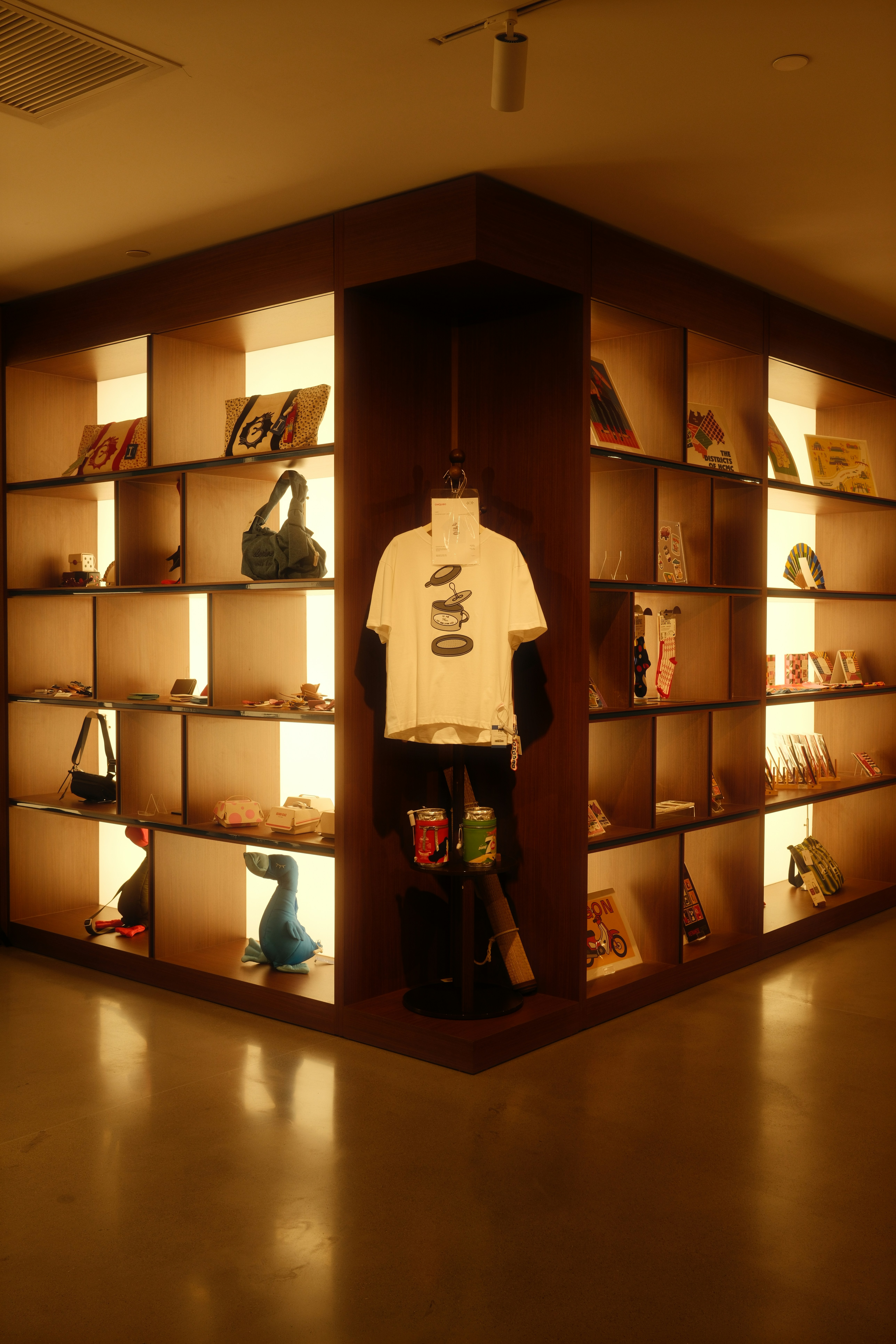 Prateleiras de canto com vários itens e uma camisa.