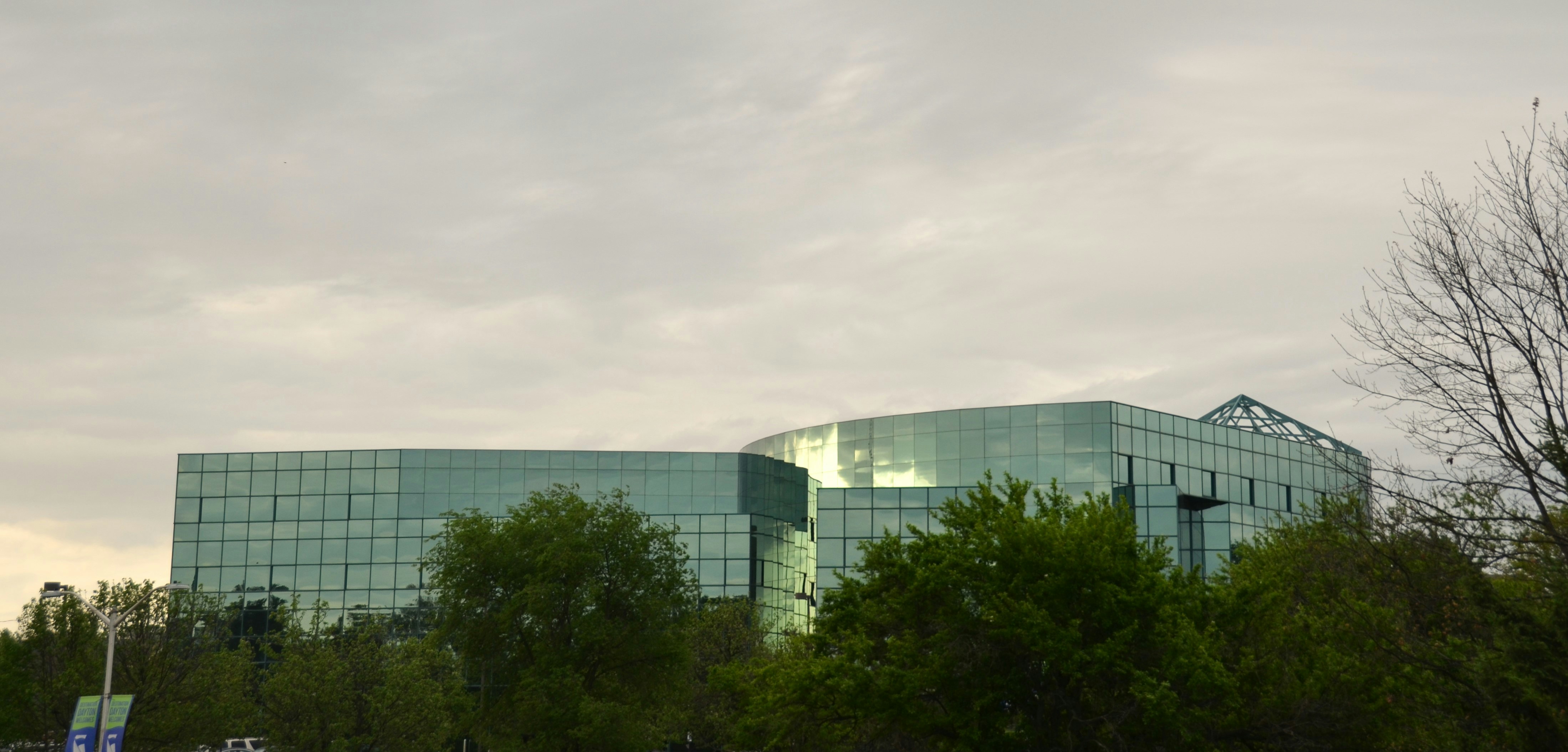 緑の木々に囲まれた現代的なガラス建築。