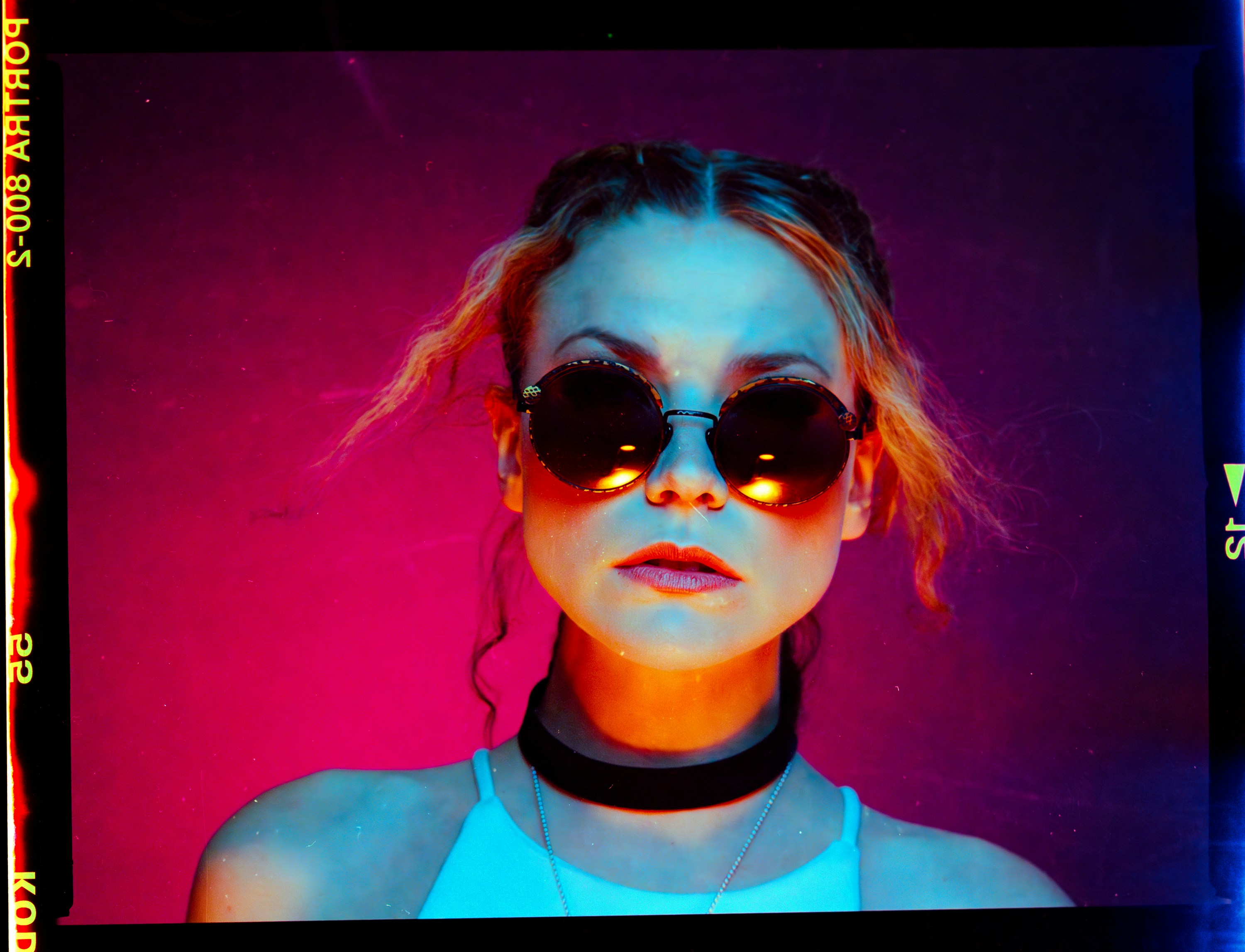 Donna con occhiali da sole e luci colorate