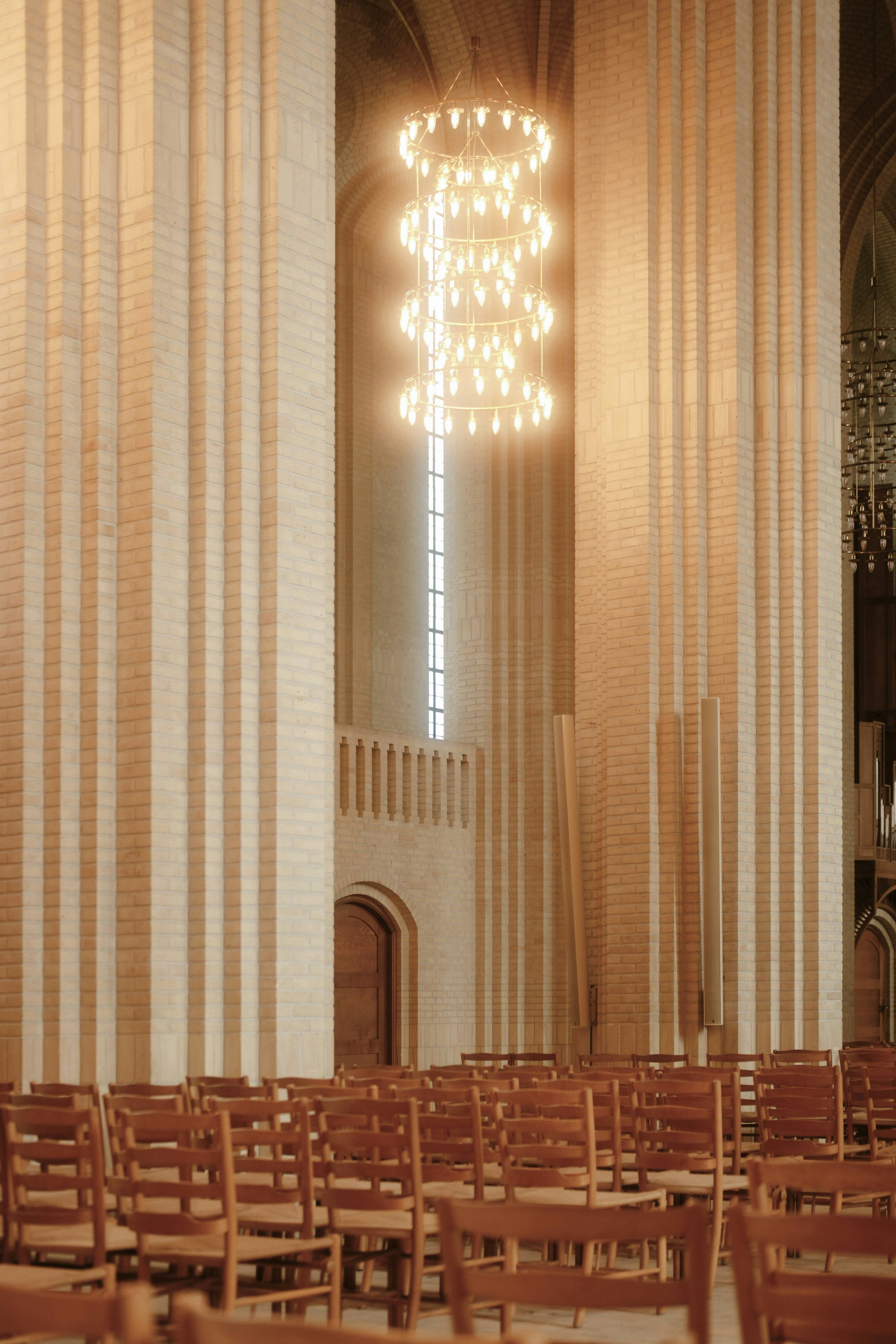 Rows of wooden chairs inside a grand hall