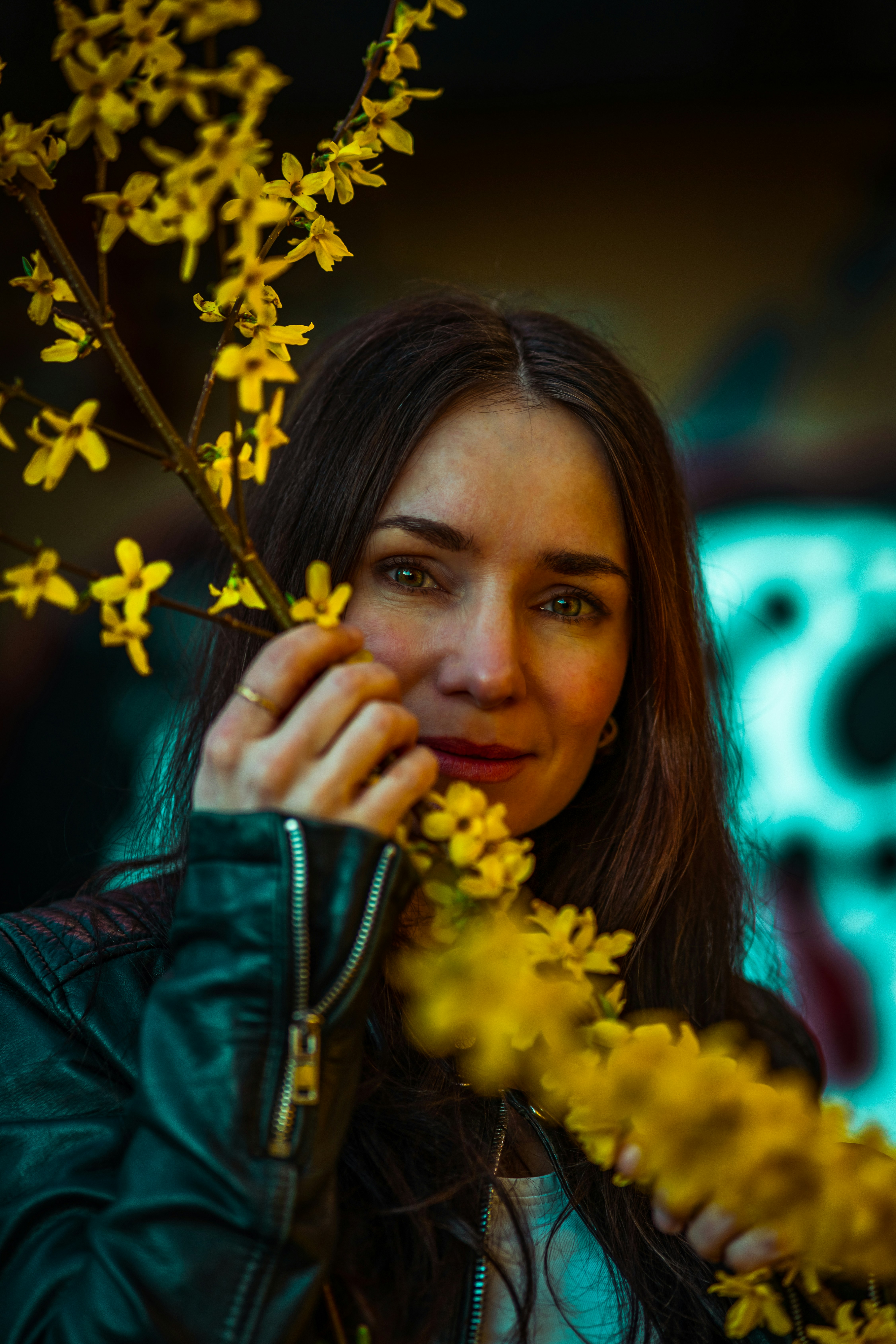 Woman with yellow flowers in front of graffiti wall
